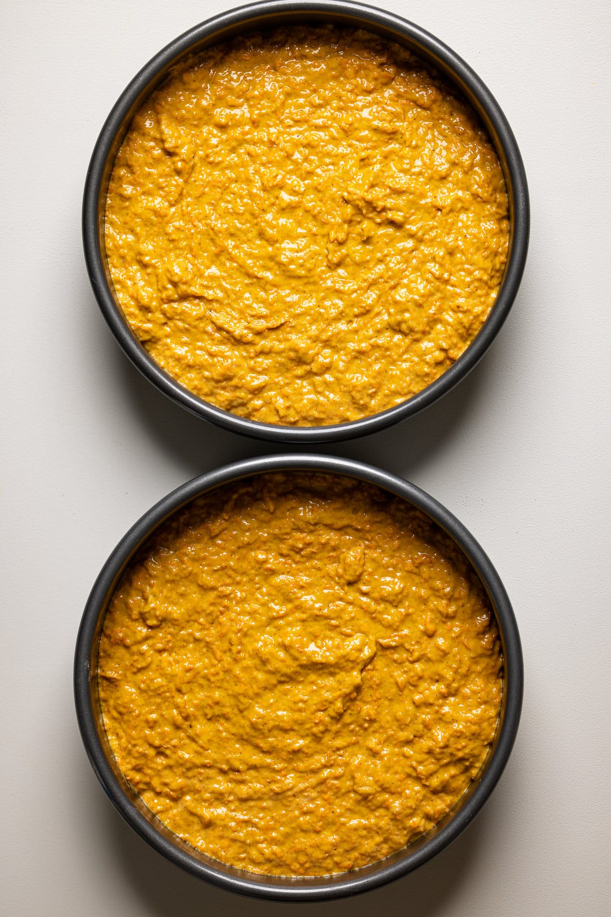 Two round pans filled with Carrot Cake batter