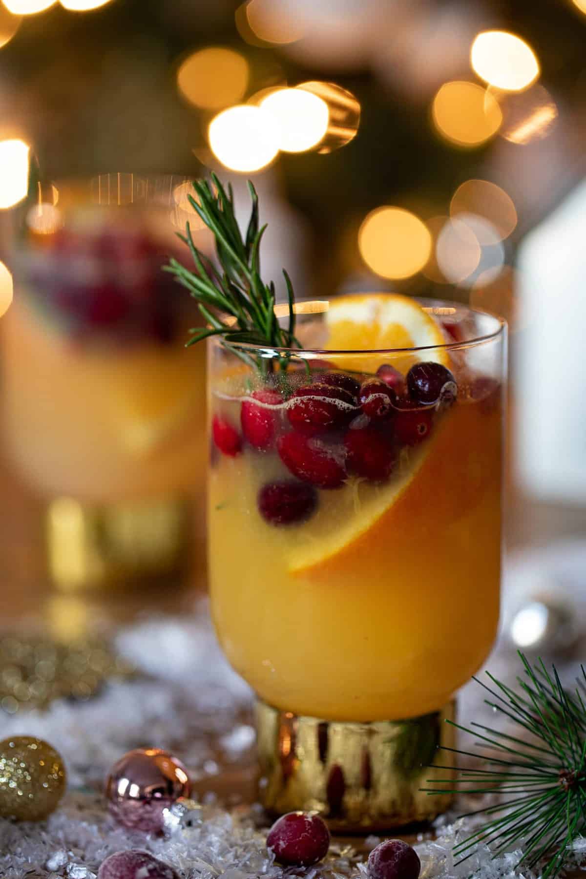 Sparkling Cranberry Orange Ginger Mocktail in a small glass with a golden base