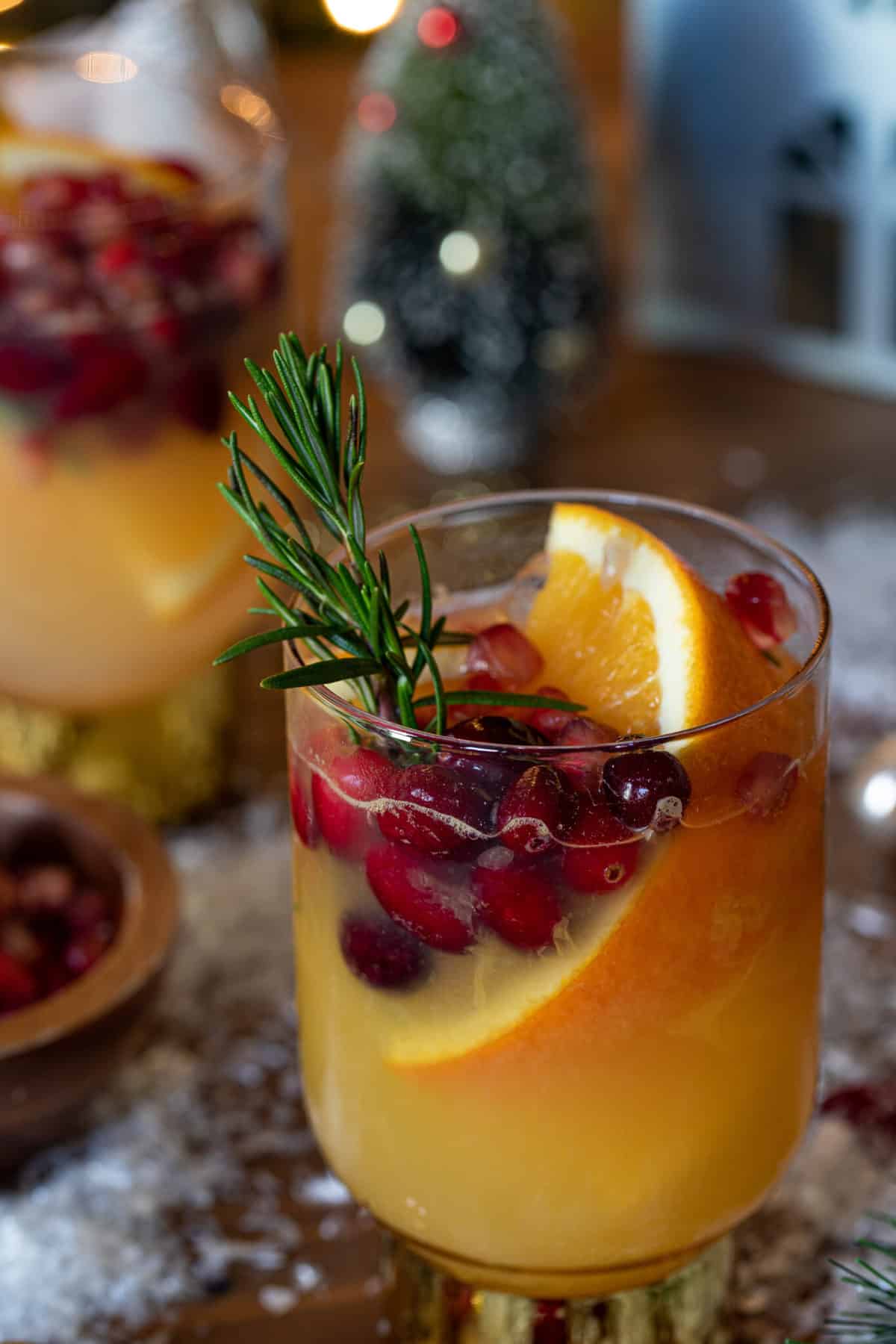 Sparkling Cranberry Orange Ginger Mocktail garnished with a sprig of rosemary.