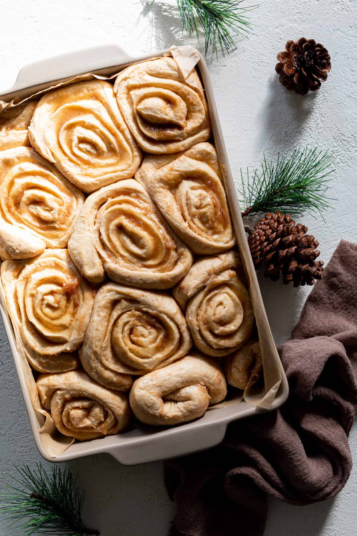 Fluffy Apple Butter Eggnog Cinnamon Rolls in a baking dish.