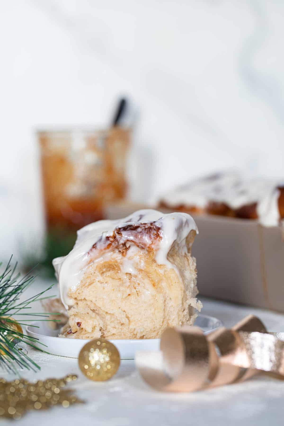 Fluffy Apple Butter Eggnog Cinnamon Roll on a small, white plate.