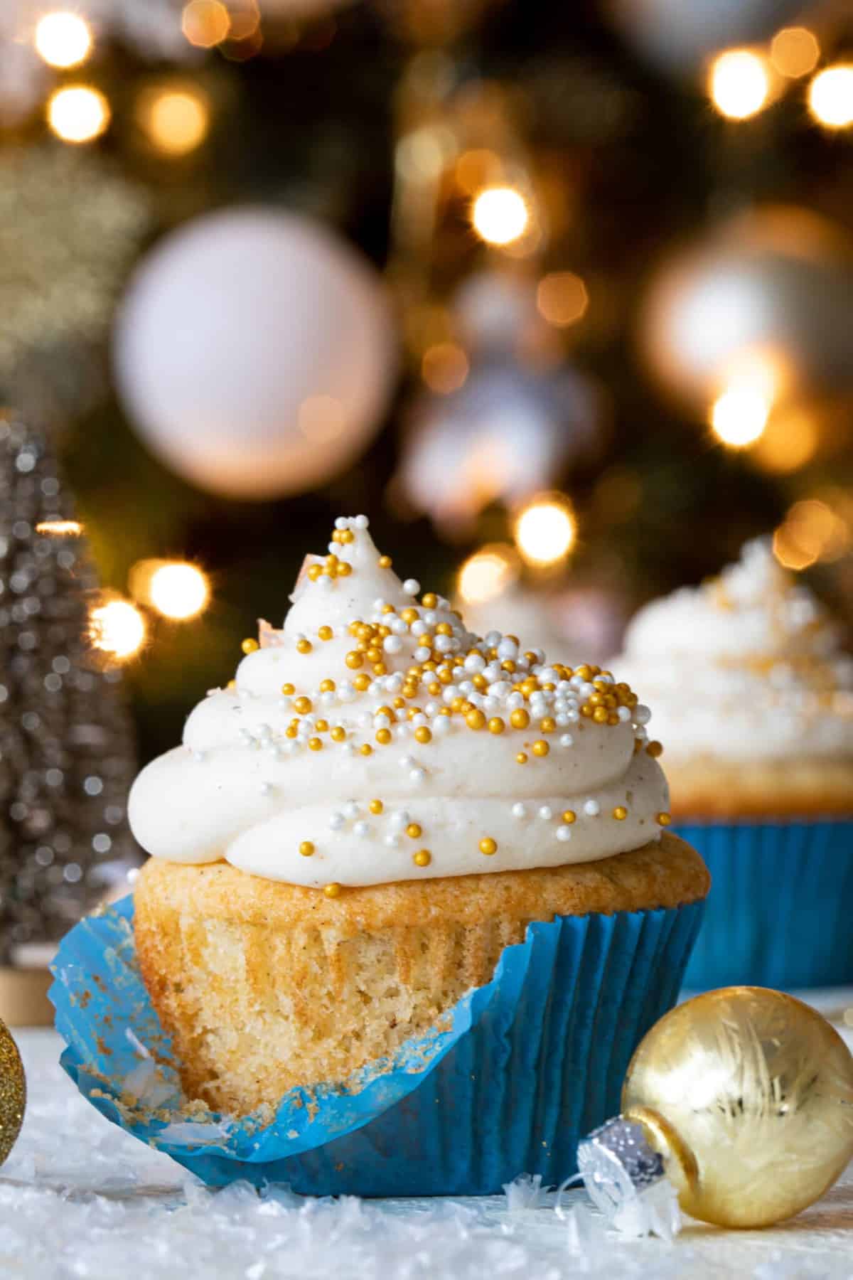 Eggnog Cupcake with Cream Cheese Frosting with a muffin liner that is partially-removed.