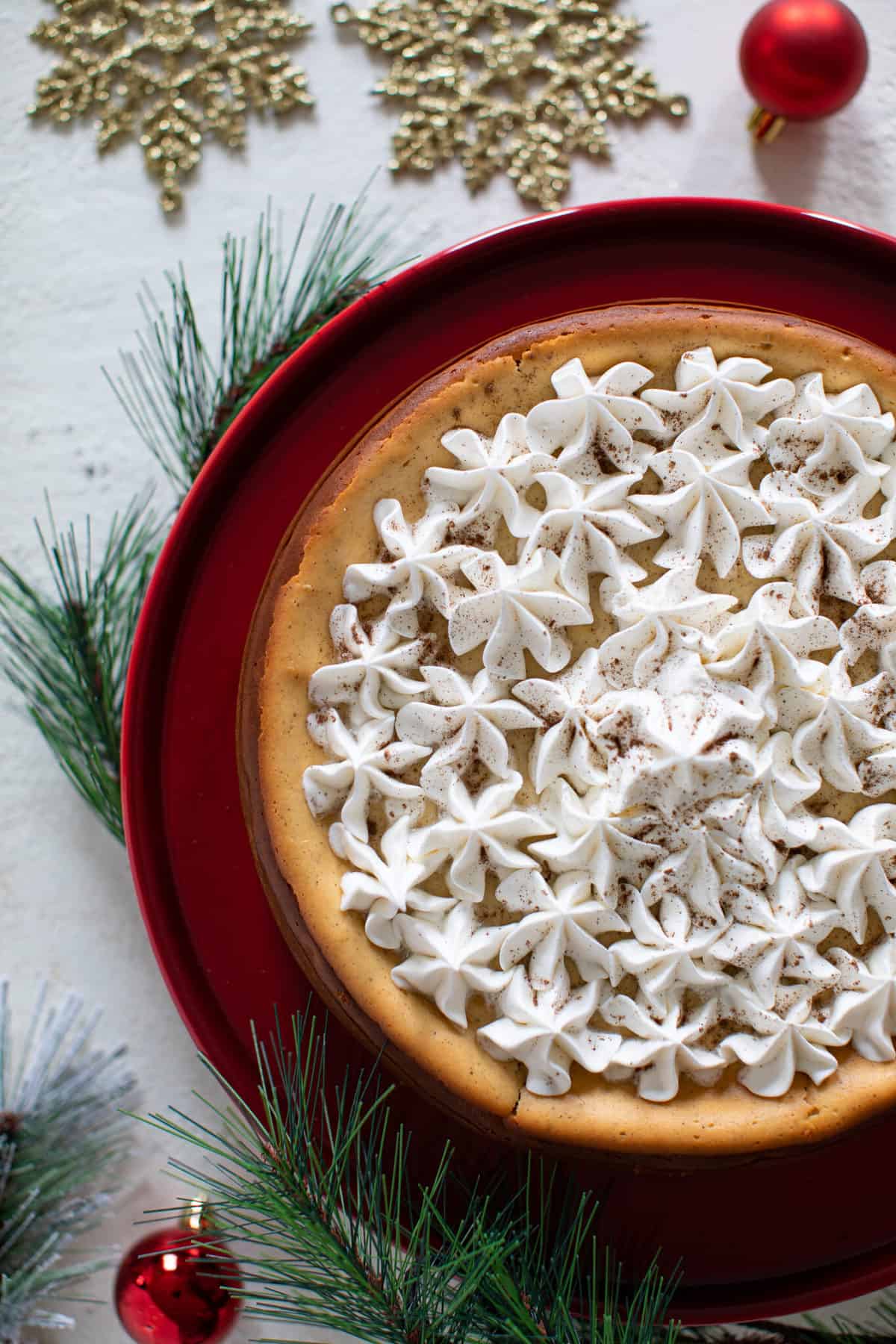 Spiced Chai Cheesecake with a Gingersnap Crust on a raised red platter.