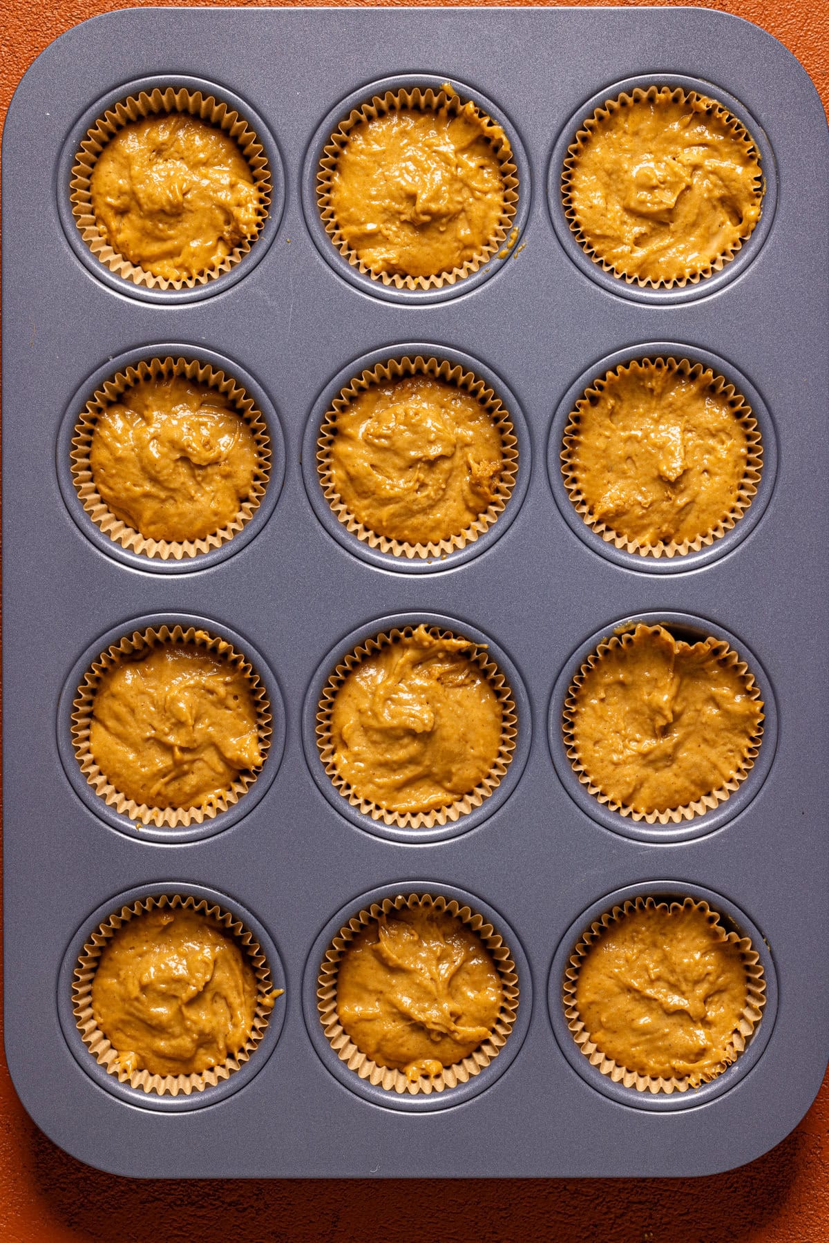 Batter in a lined muffin pan.