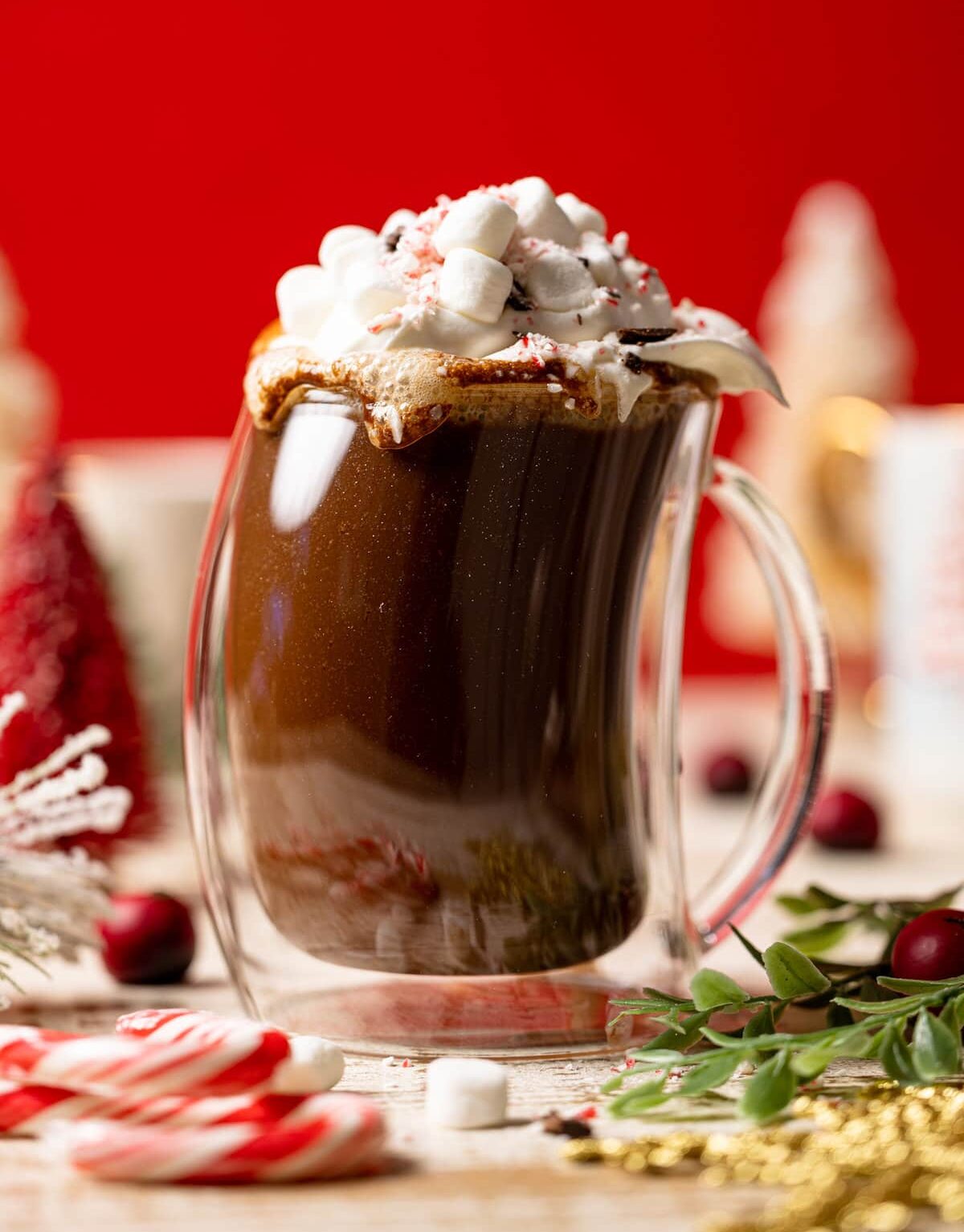 Homemade Peppermint Mocha Latte in a lopsided glass topped with whipped cream and marshmallows