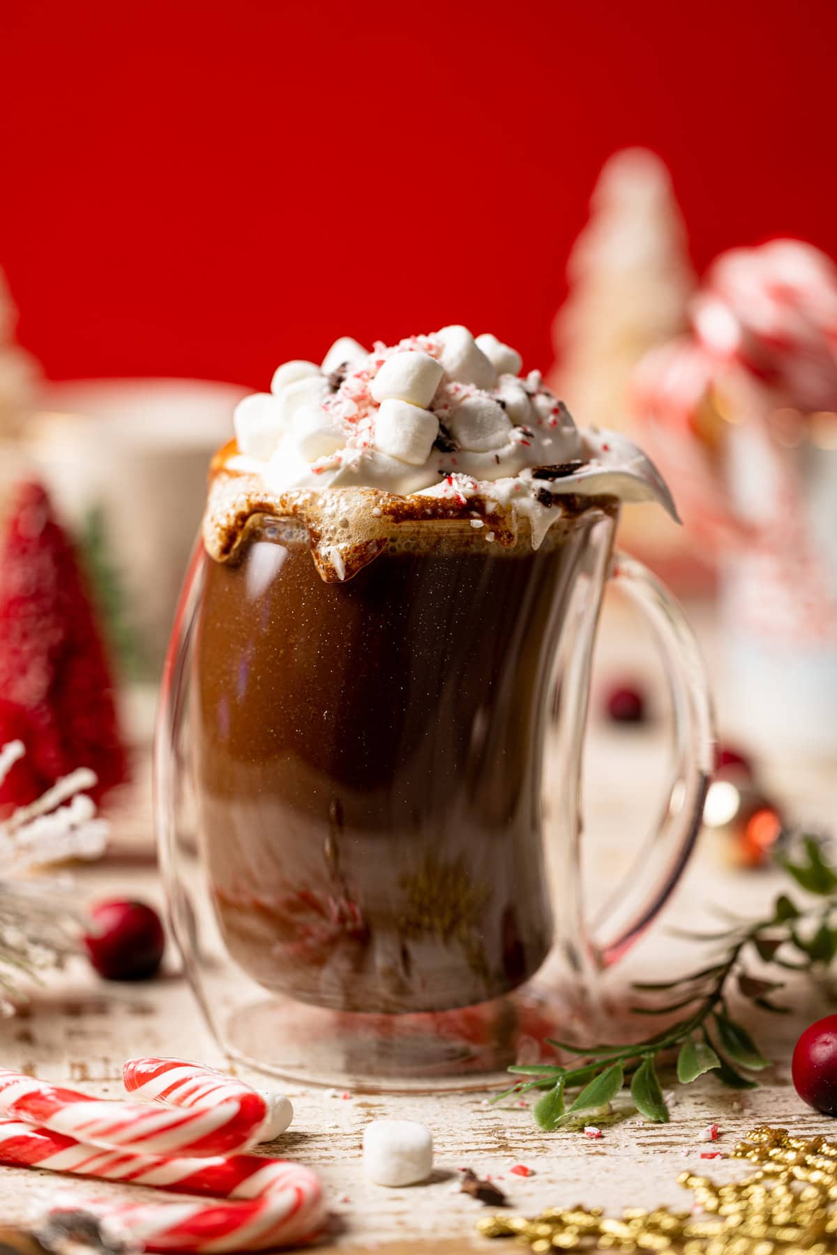 Homemade Peppermint Mocha Latte in a lopsided glass topped with whipped cream and marshmallows