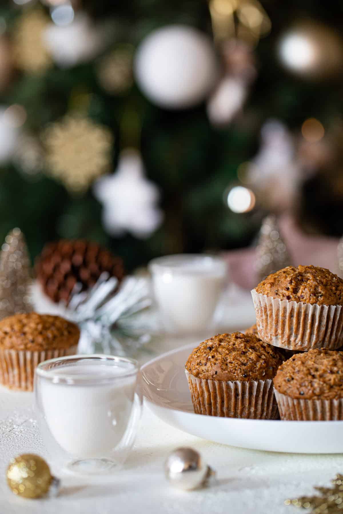 Pile of Vegan Gingerbread Quinoa Muffins on a plate next to a glass of milk.