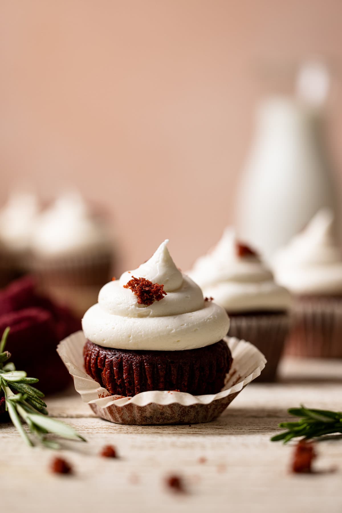 Vegan Red Velvet Cupcake with Bourbon Vanilla Buttercream with the muffin liner partially-removed.