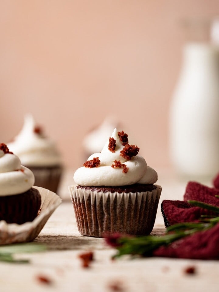 Vegan Red Velvet Cupcakes with Bourbon Vanilla Buttercream on a wooden table.