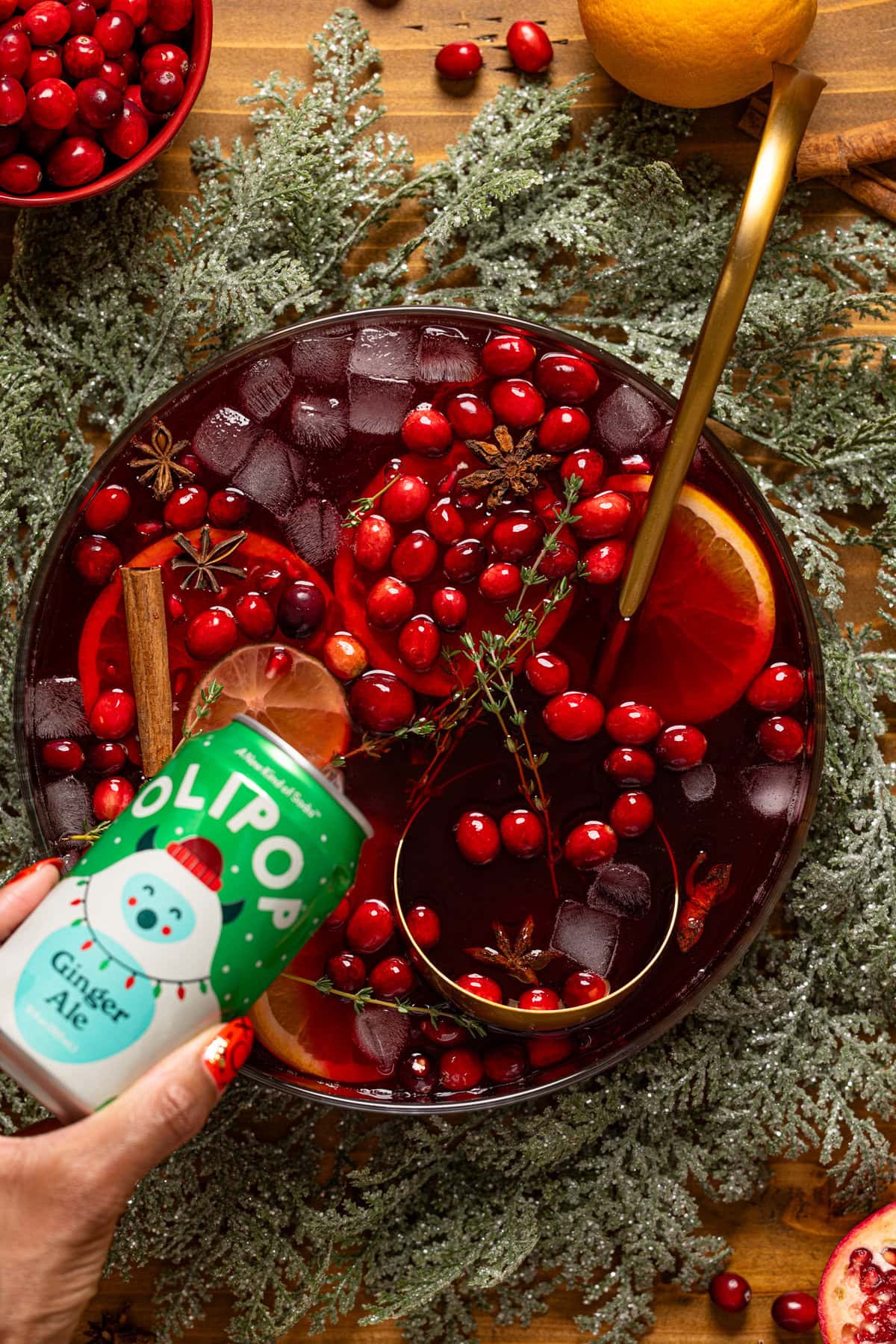 A can of Olipop being poured into a bowl with Christmas Punch.