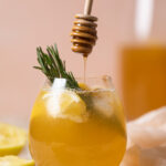 Honey drizzling into a glass of Apple Cider Vinegar Detox Lemonade
