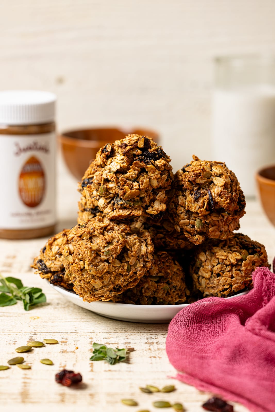 Cookies on a plate with milk and almond butter with garnish.