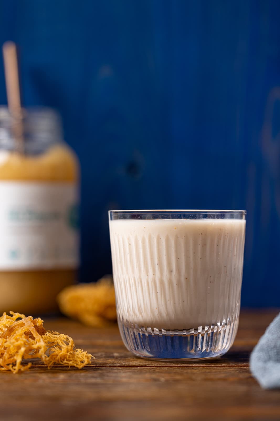 Irish moss drink in a glass with sea moss gel in the background.