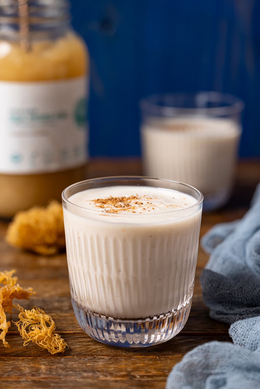 Up close shot of irish moss drinks with sea moss on a brown wood table.