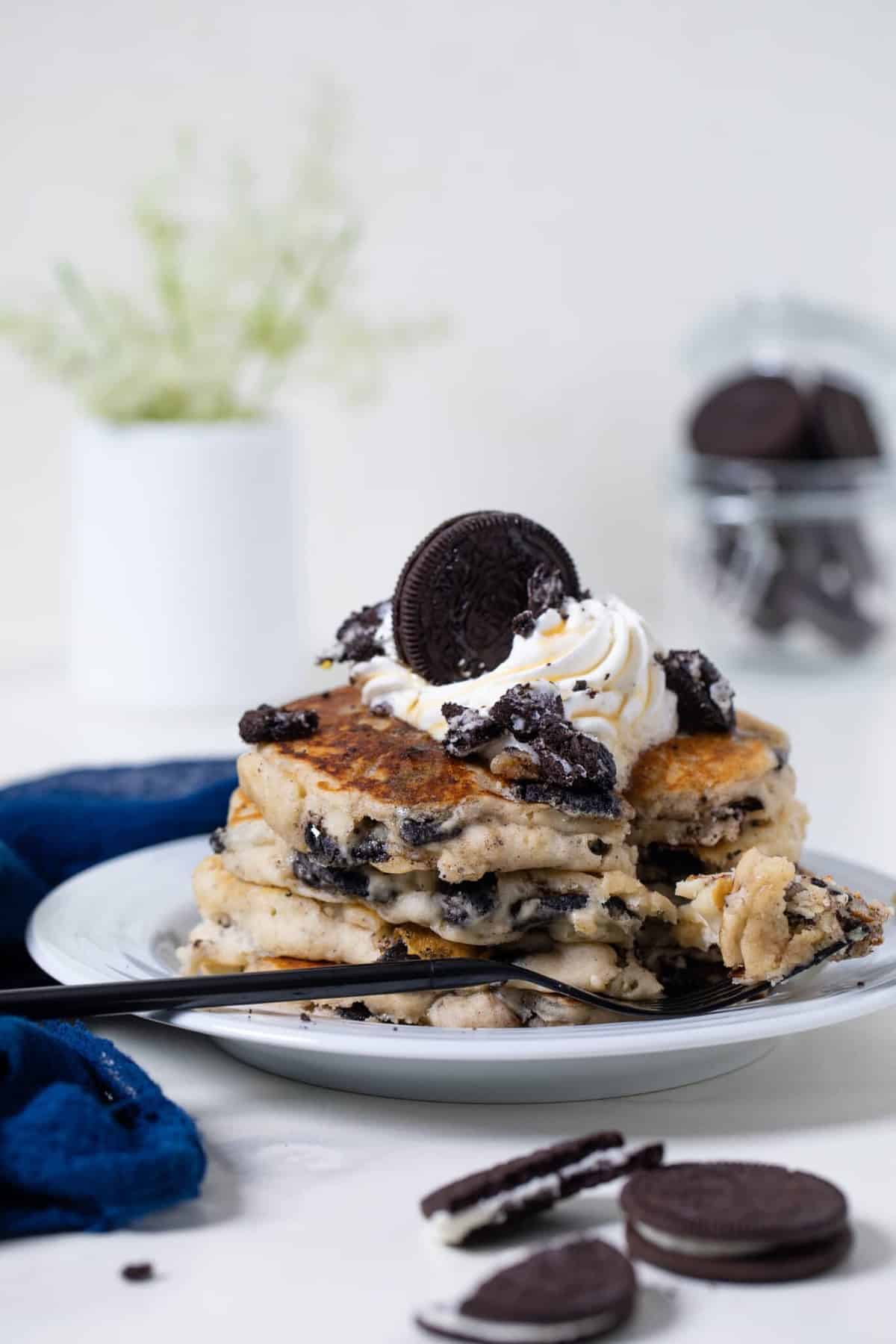 Stack of  Fluffy Vegan Oreo Pancakes with a bite missing.
