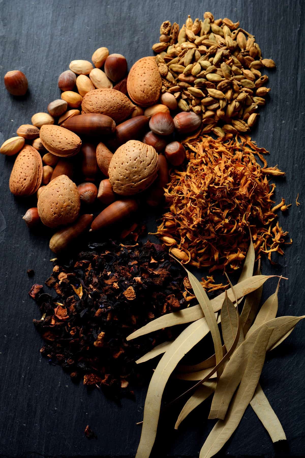 Nuts and spices on a black table.