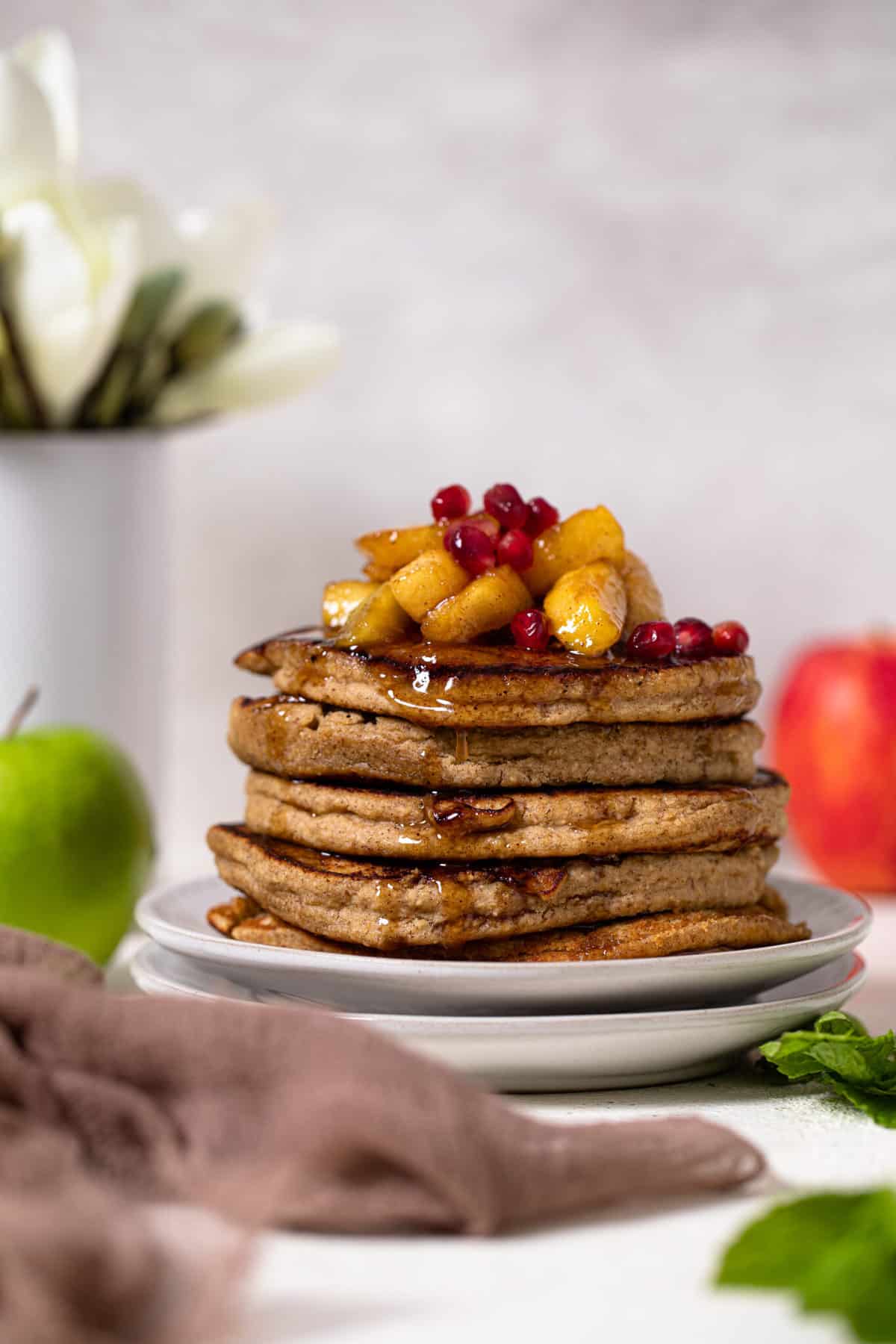 Stack of Flourless Apple Pancakes topped with fruit.