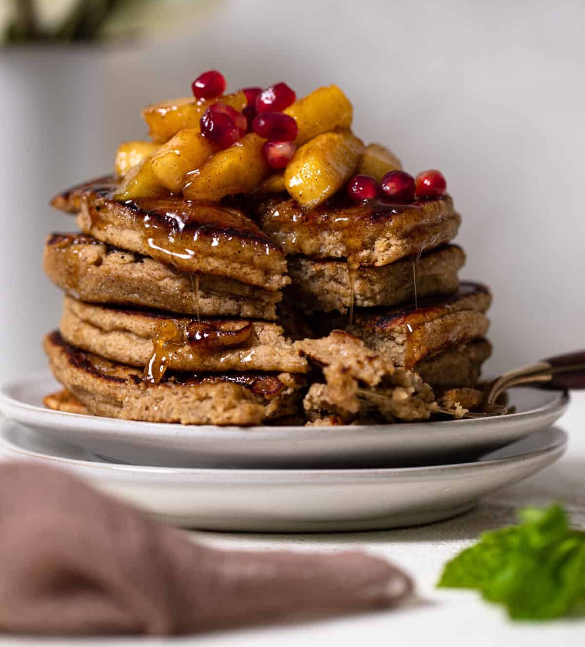 Flourless Apple Pancakes stacked on two white plates.