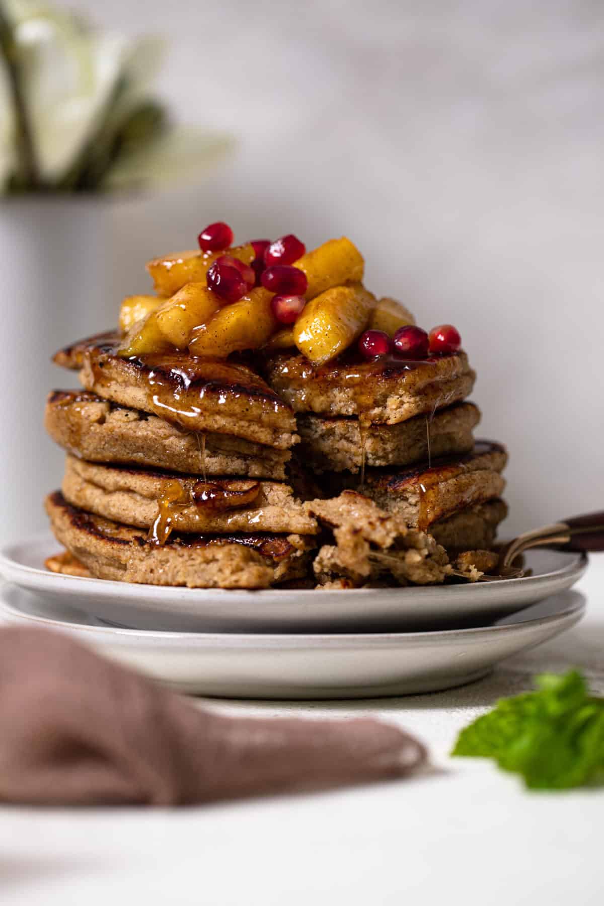 Flourless Apple Pancakes stacked on two white plates.