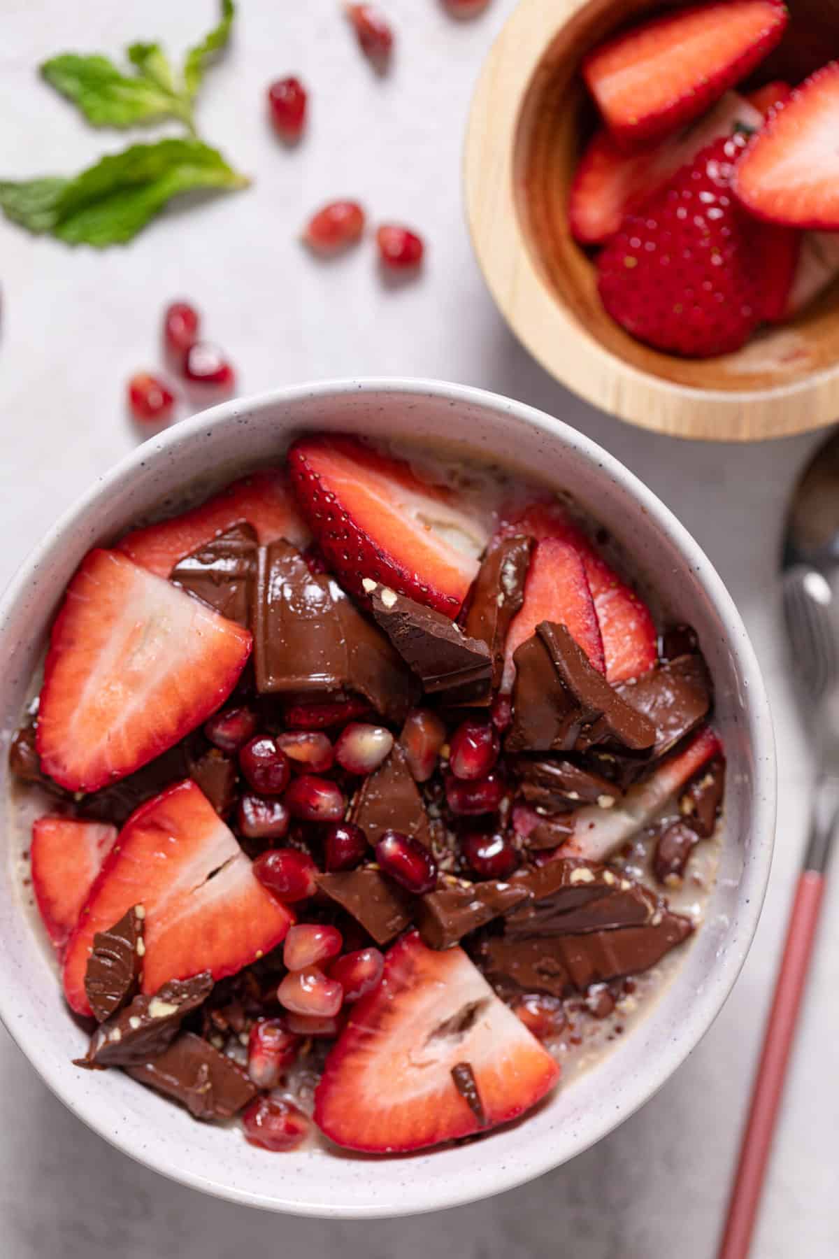 Breakfast Bowl with strawberries, pomegranate seeds, and chocolate.