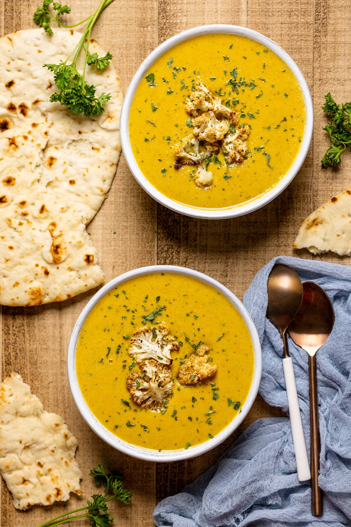 Two bowls of Creamy Roasted Garlic Cauliflower Chickpea Soup