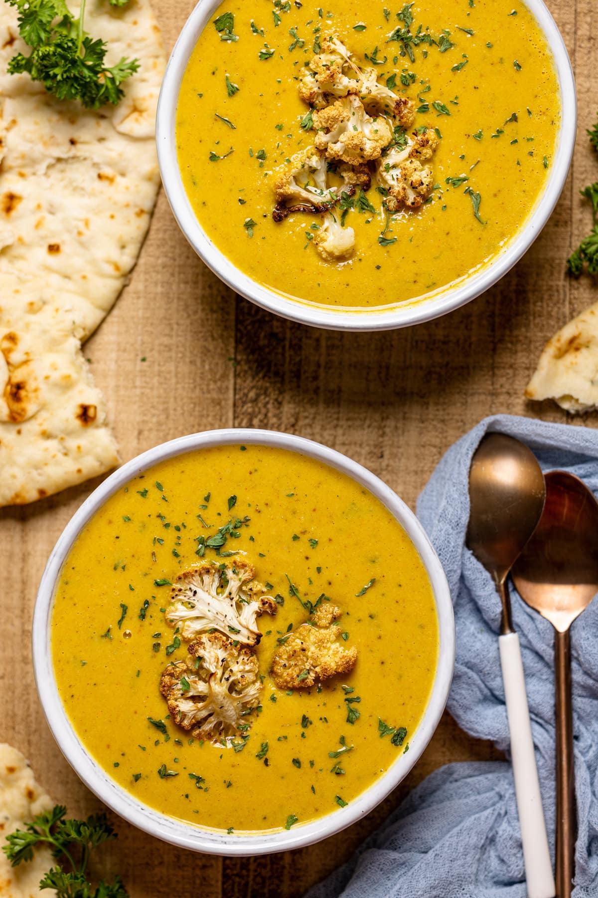 Two bowls of Creamy Roasted Garlic Cauliflower Chickpea Soup