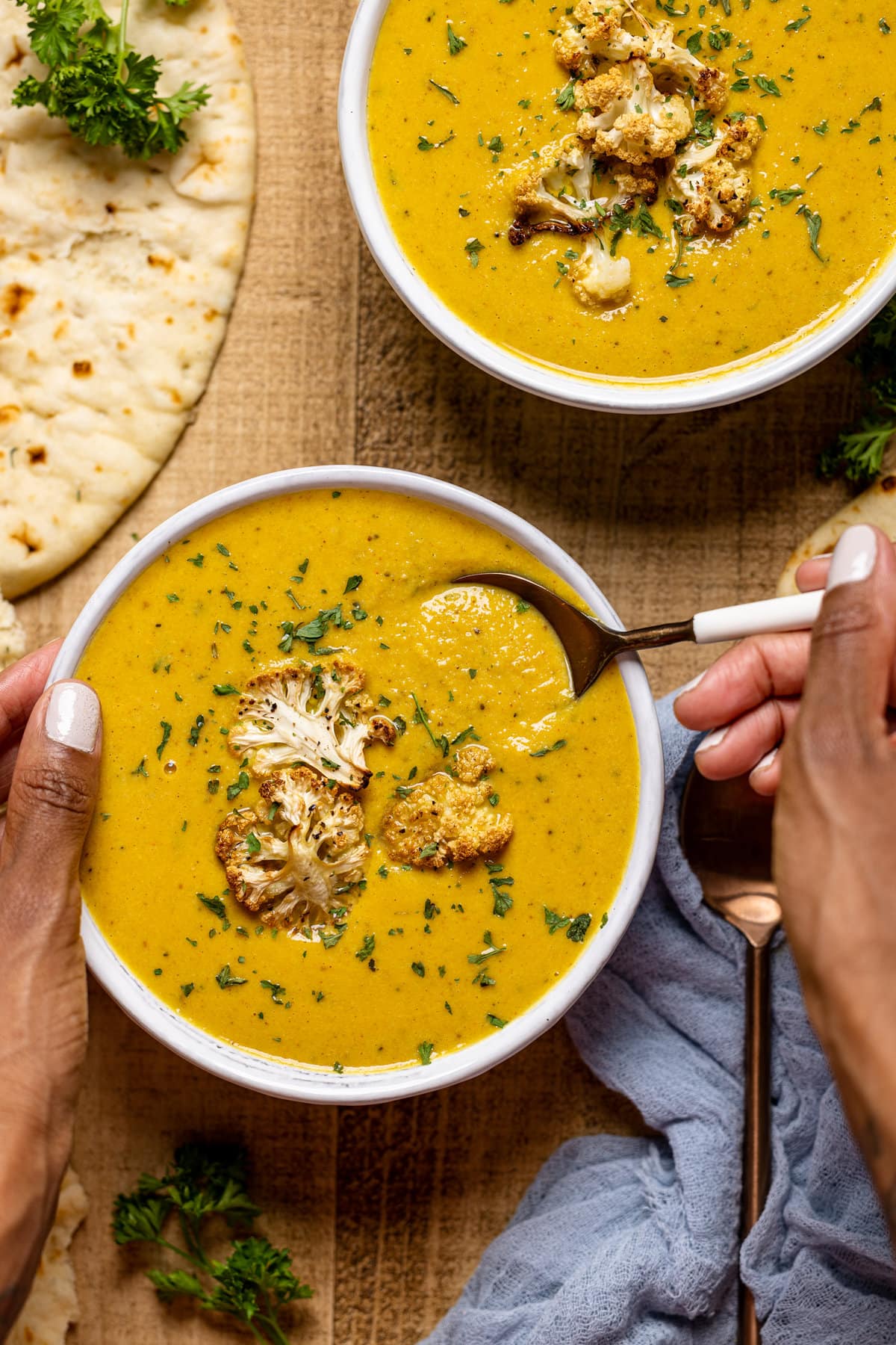 Spoon scooping some Creamy Roasted Garlic Cauliflower Chickpea Soup out of a bowl