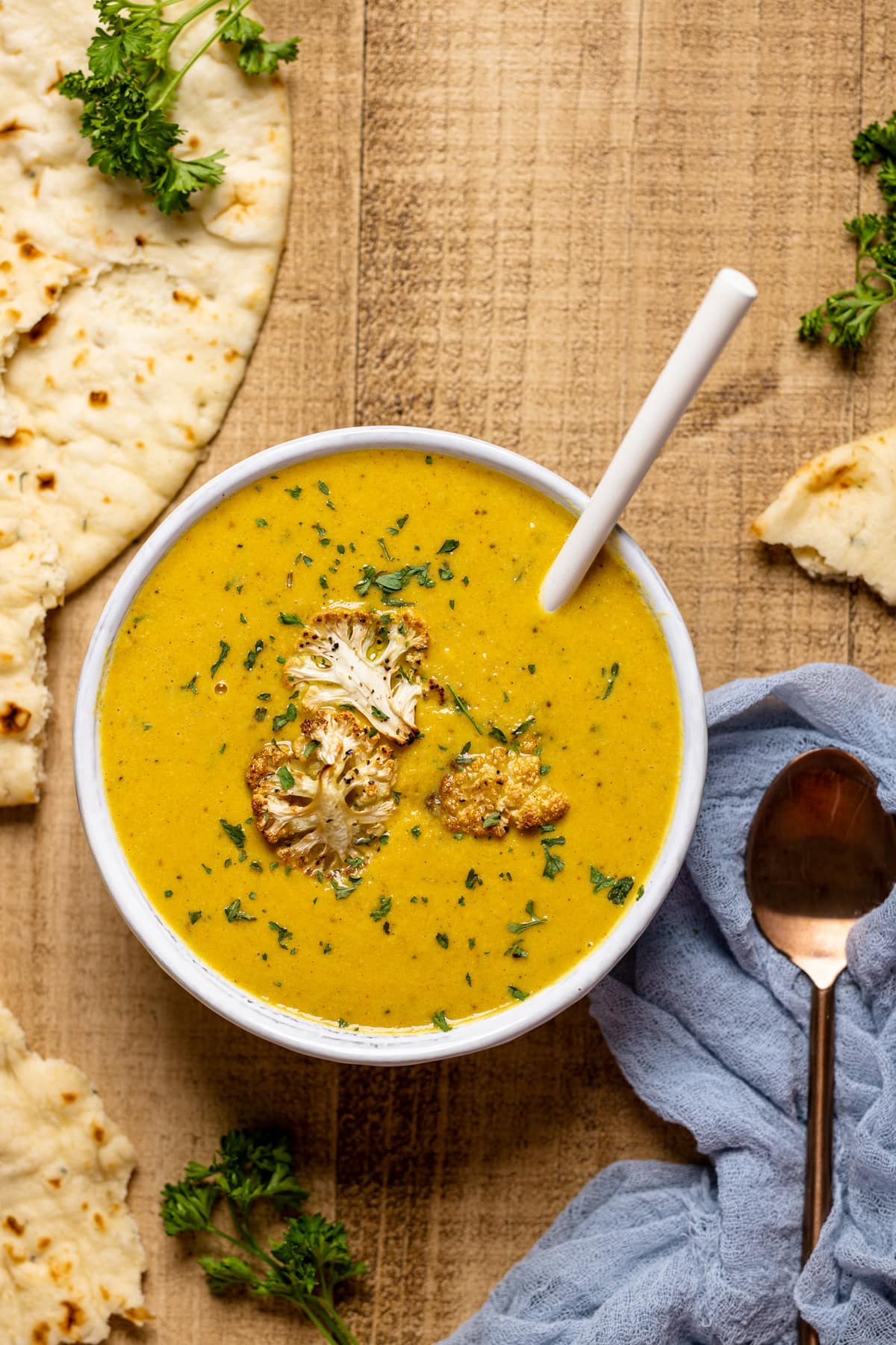 Bowl of Creamy Roasted Garlic Cauliflower Chickpea Soup with a spoon