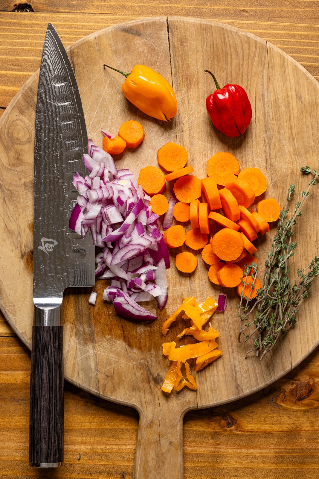 Veggies chopped on a cutting board with a knife.