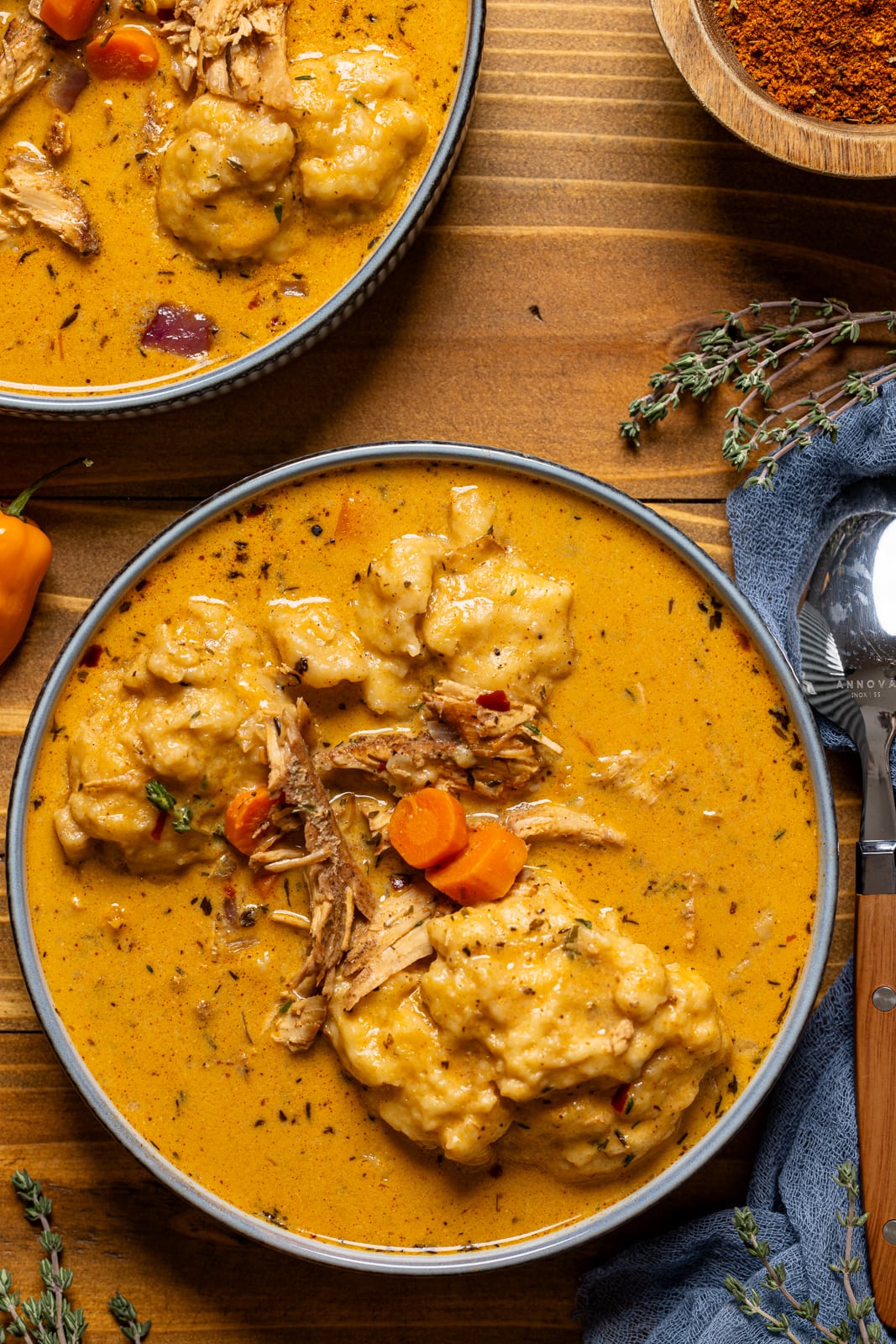 Bowls of chicken and dumplings with a spoon.