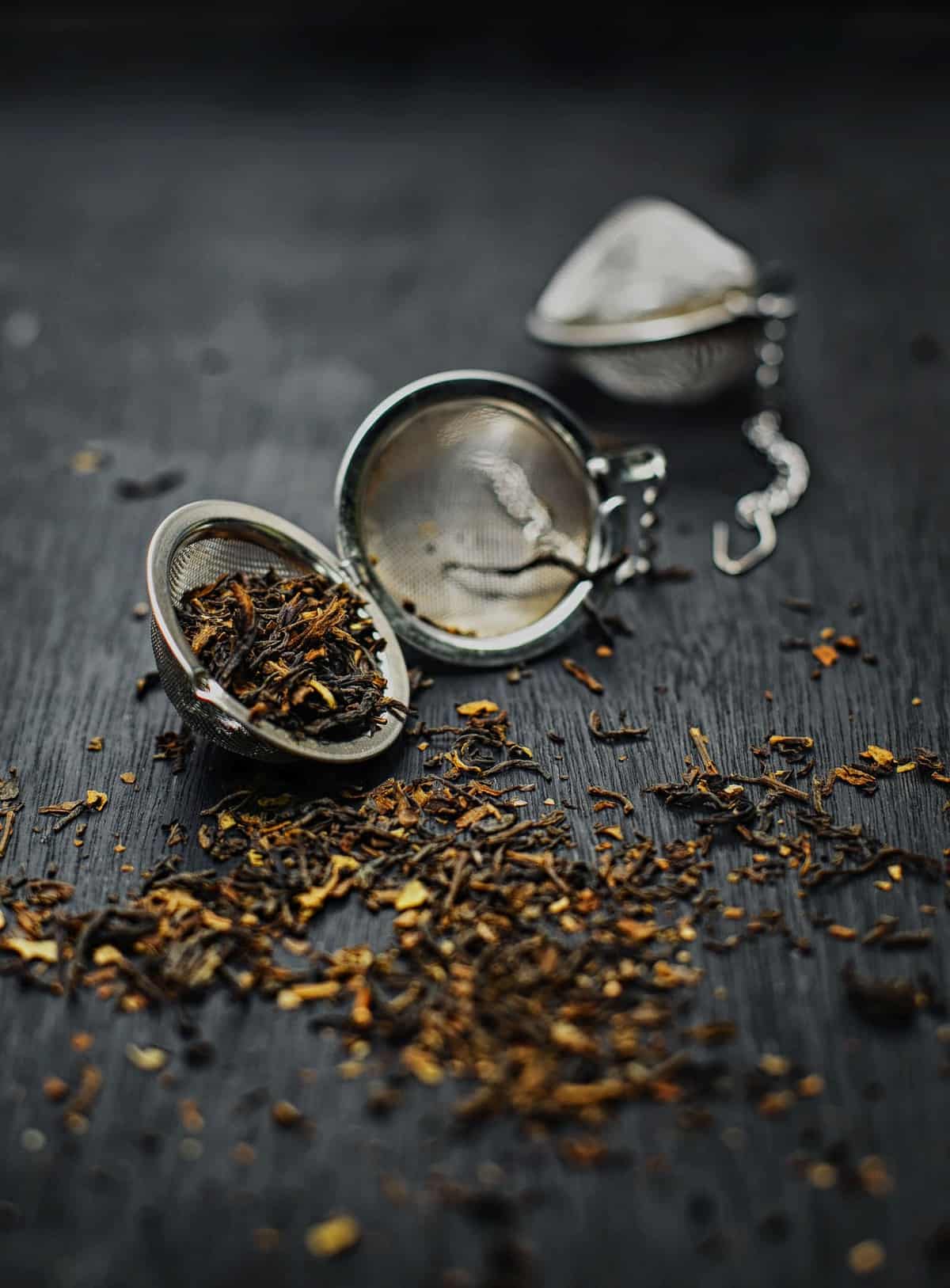 Mesh tea ball with tea leaves falling out.