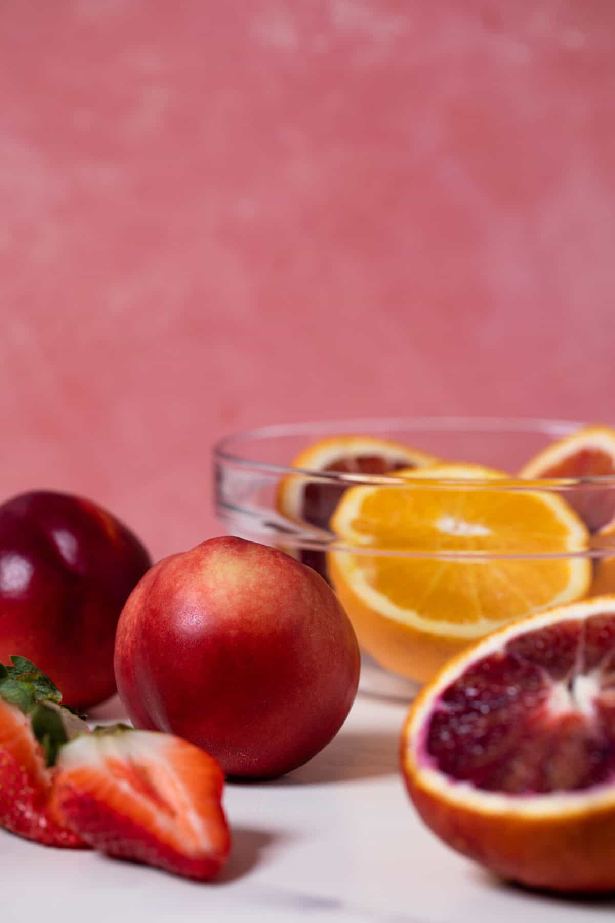 Blood Oranges and strawberries on a countertop.