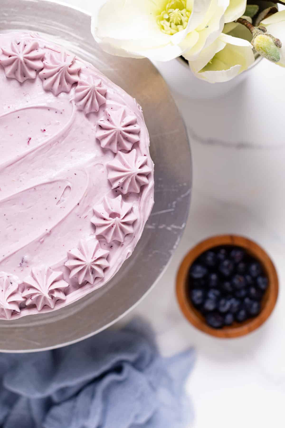 Blueberry Oatmeal Cake with Cream Cheese Frosting on a cake stand.