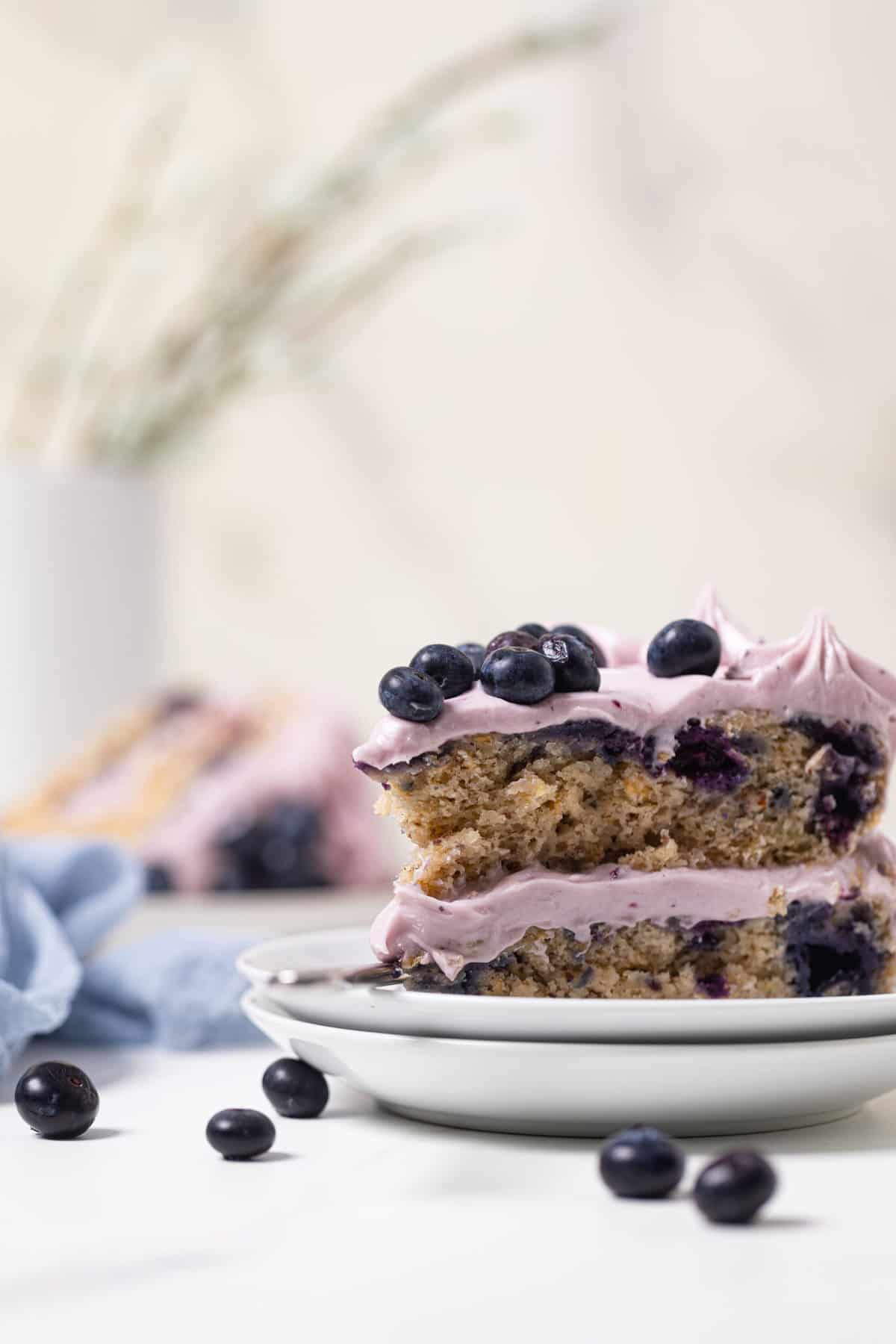 Slice of Blueberry Oatmeal Cake with Cream Cheese Frosting on two small, stacked plates.