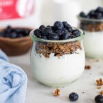 Close up on a clear glass jar with blueberry vegan parfaits.