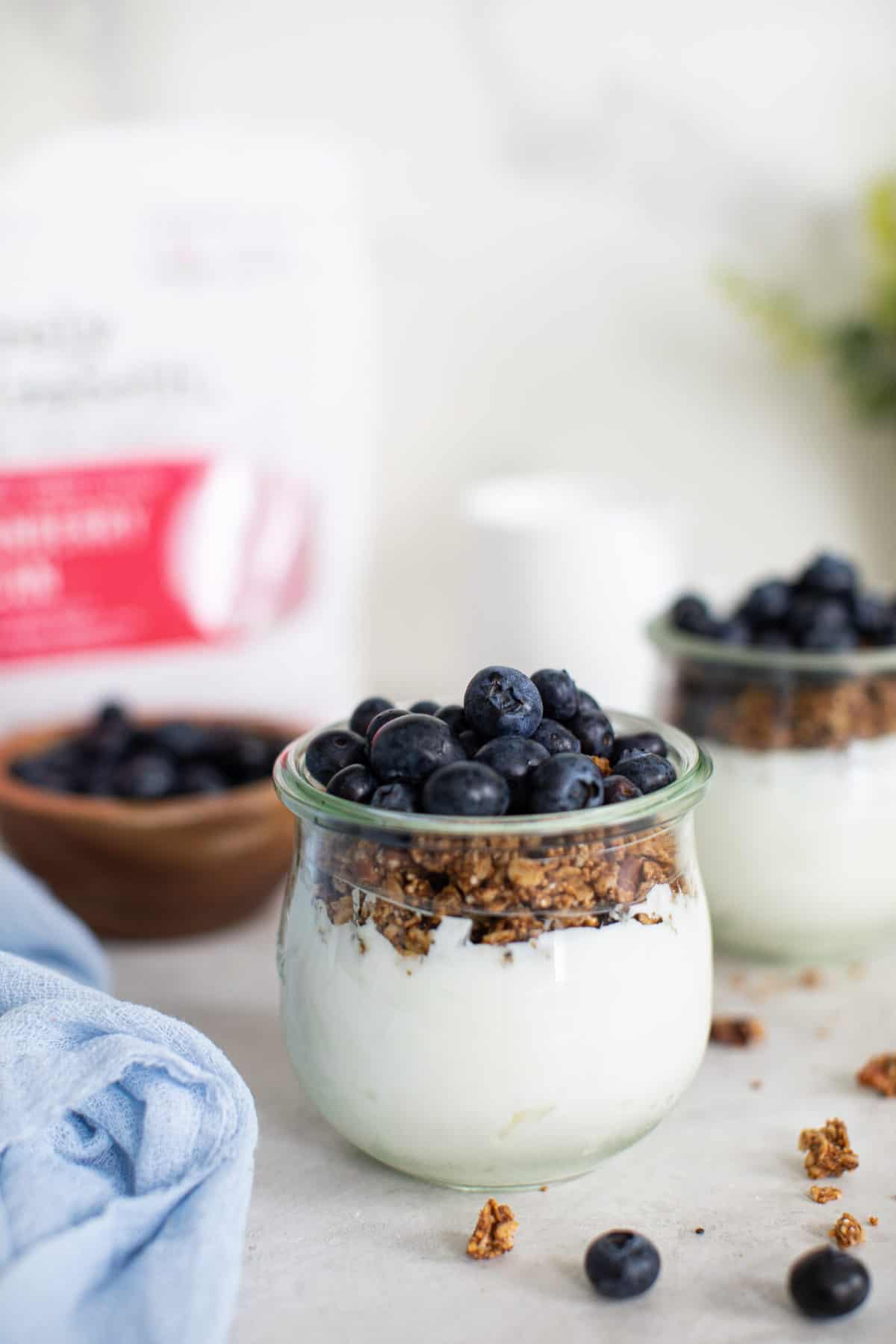 Close up on a clear glass jar with blueberry vegan parfaits.