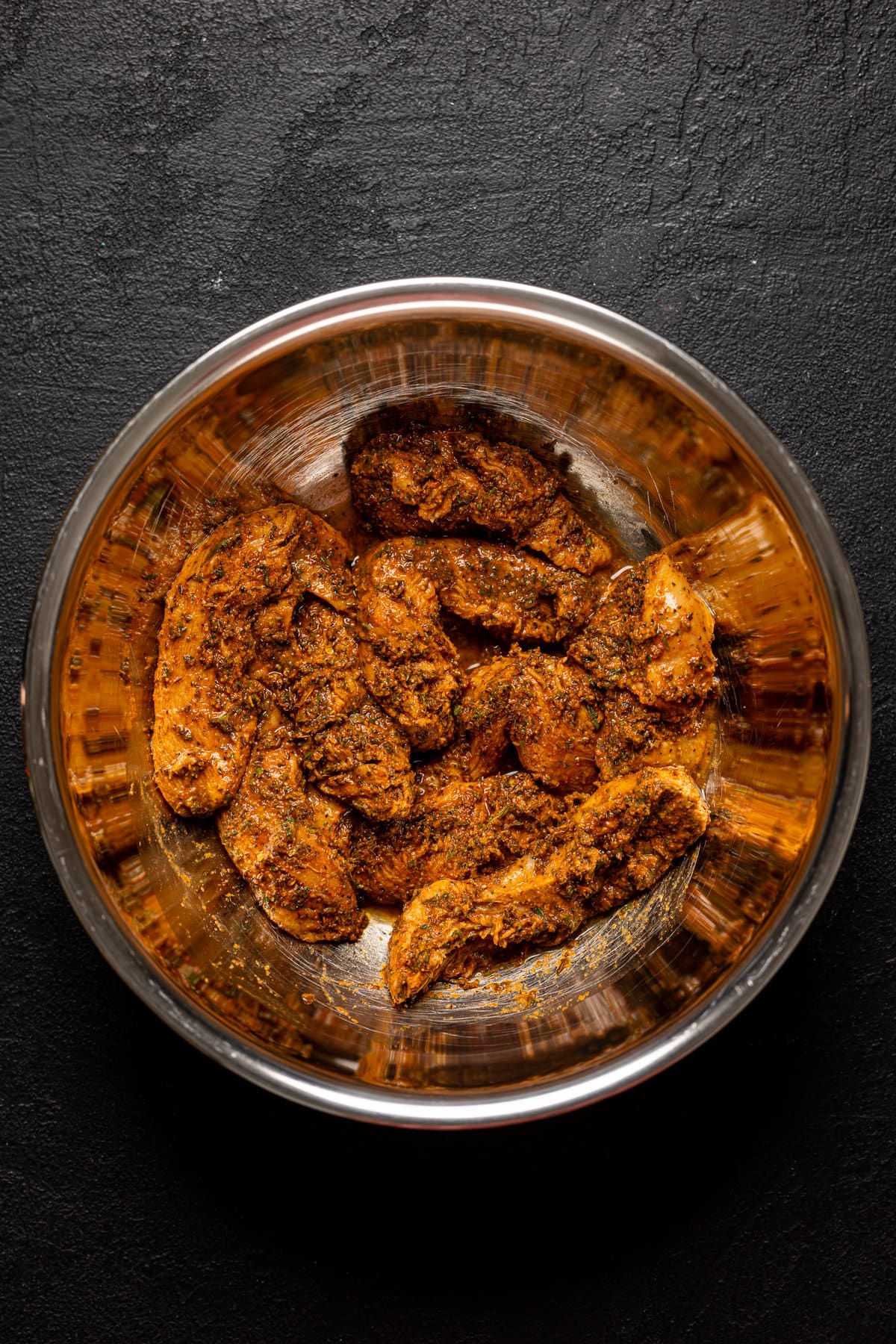 Seasoned chicken tenders in a bowl.