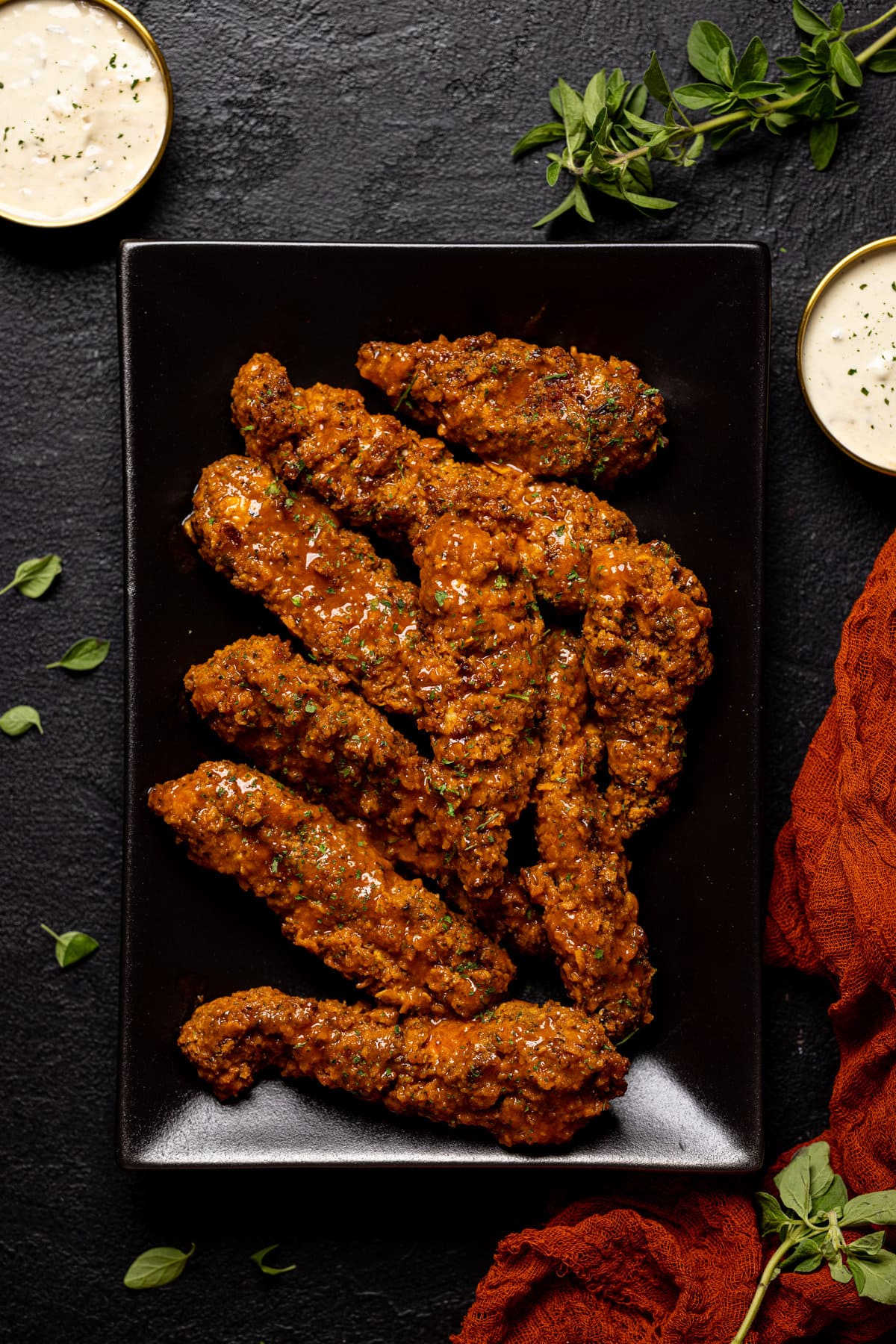 Crispy Buffalo Chicken Tenders on a black, rectangular plate.