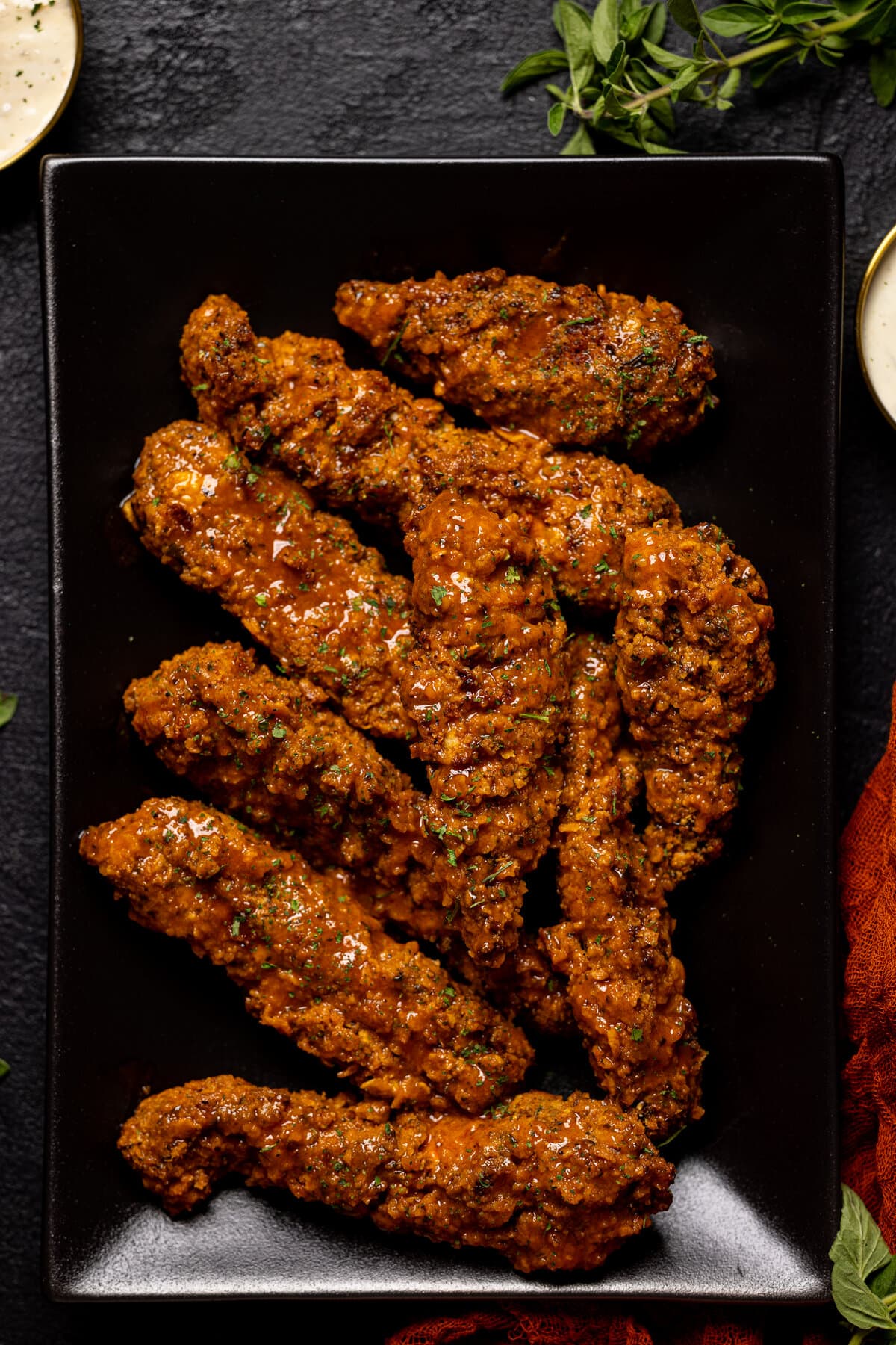 Crispy Buffalo Chicken Tenders piled on a black plate.