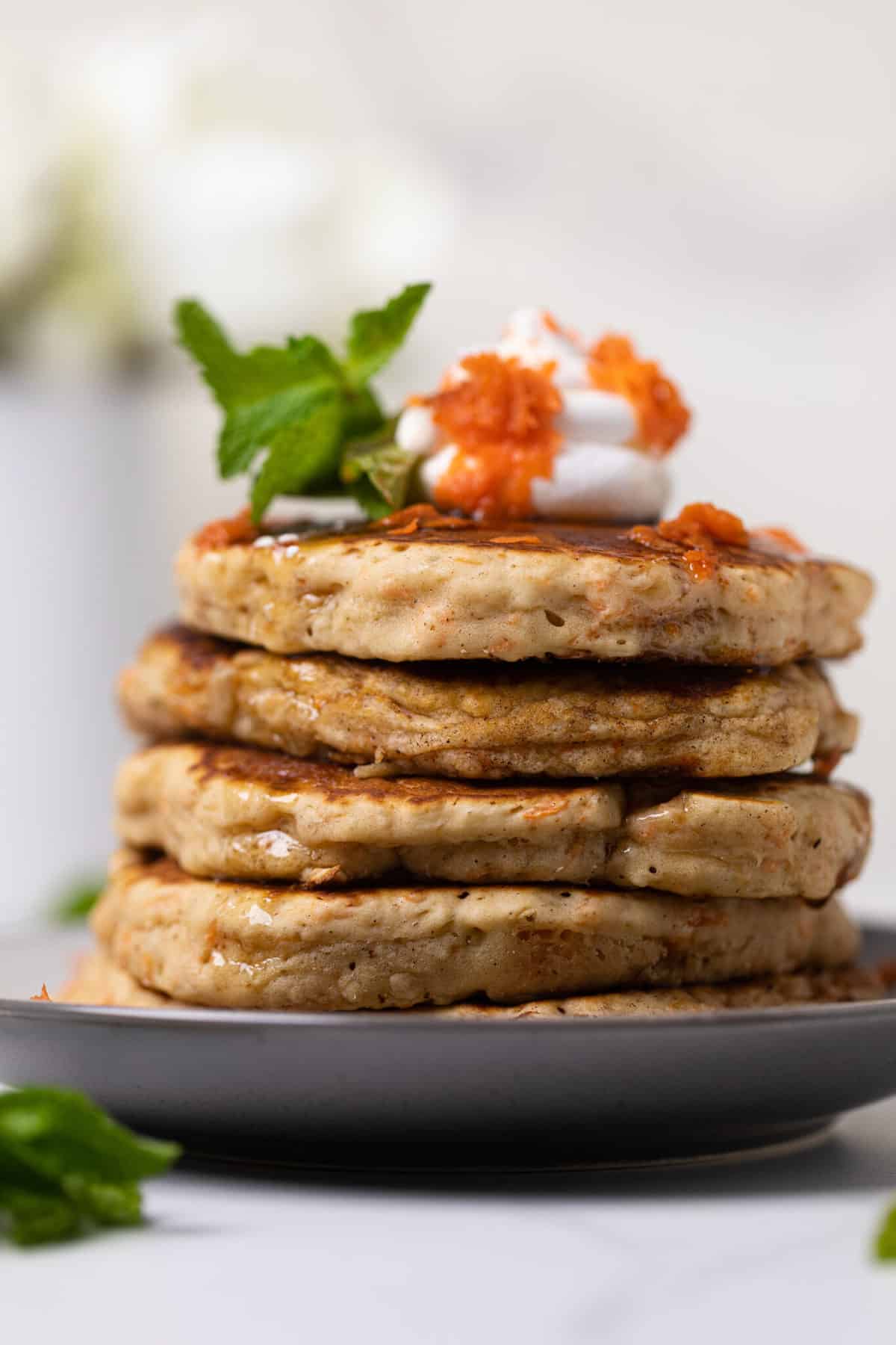 Vegan Carrot Cake Pancakes stacked on a plate.