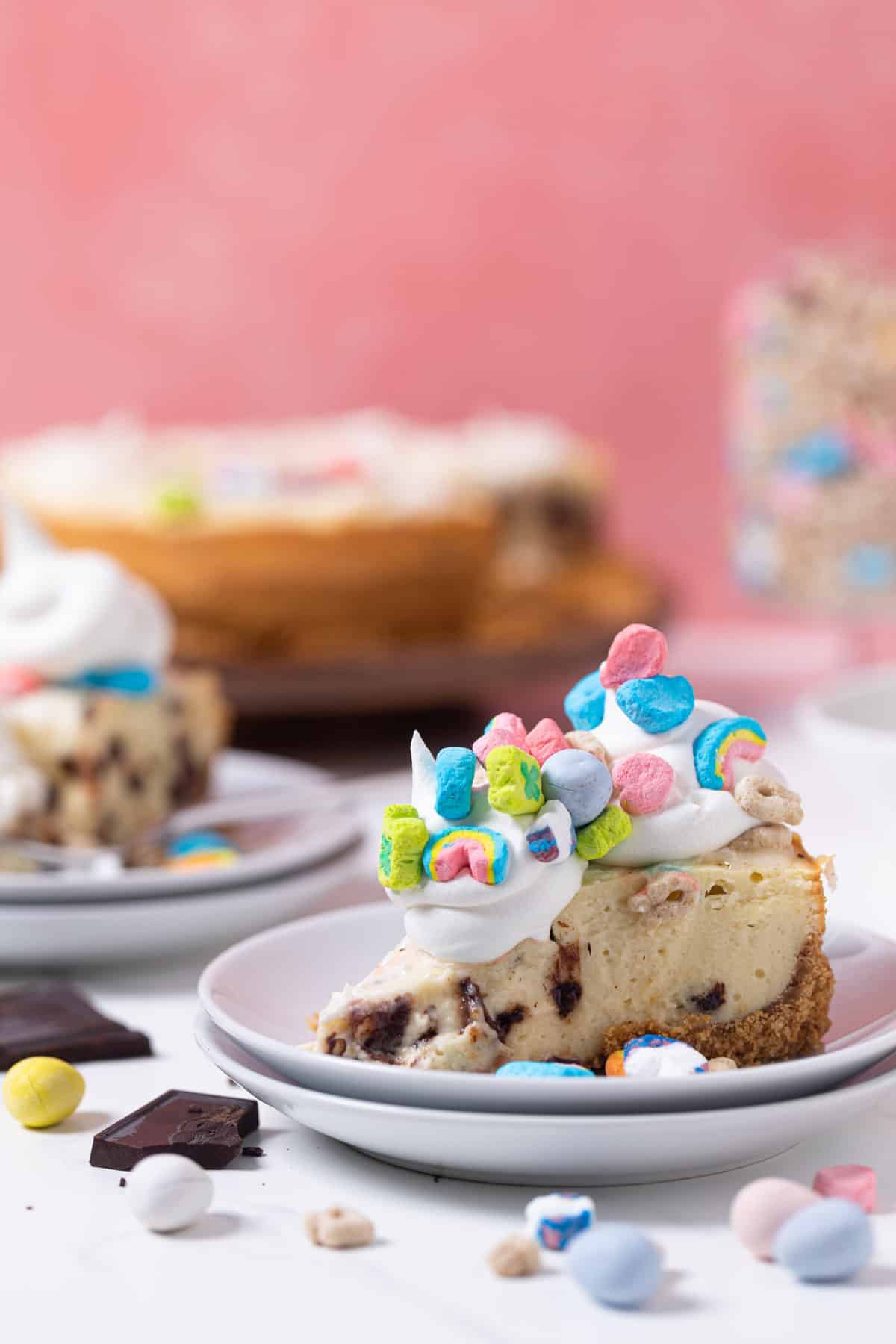 Slices of Chocolate Chip Lucky Charms Cheesecake on small plates.