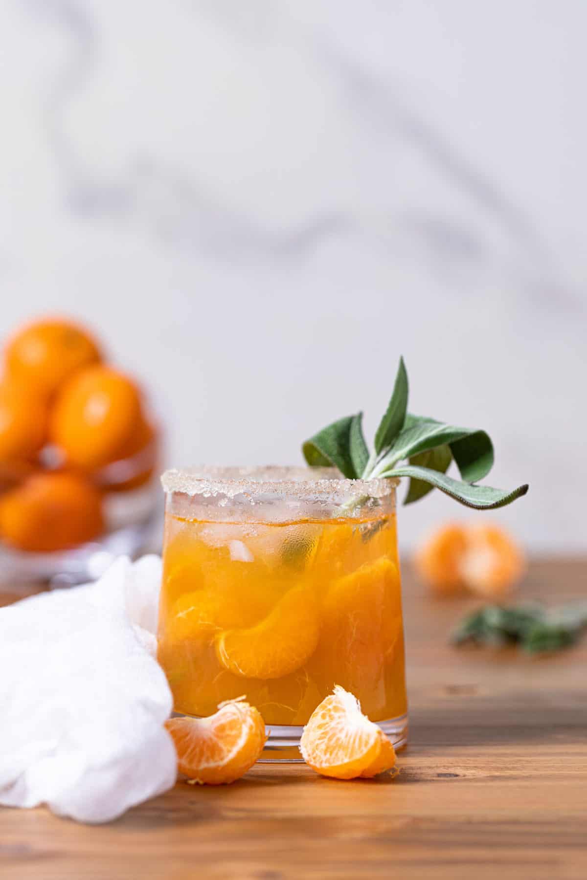 Glass of Citrus Honey Sage Drink on a wooden surface.