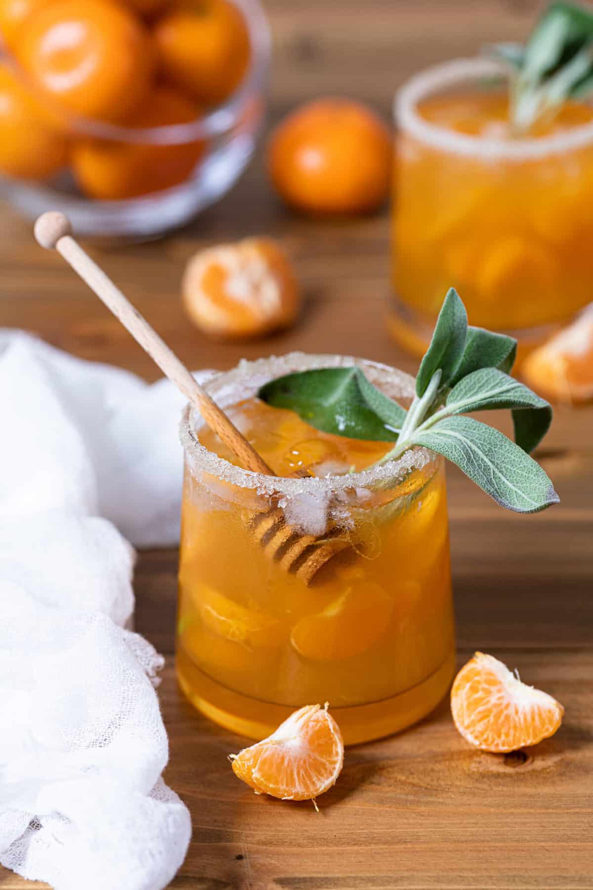 Citrus Honey Sage Drink surrounded by orange pieces.