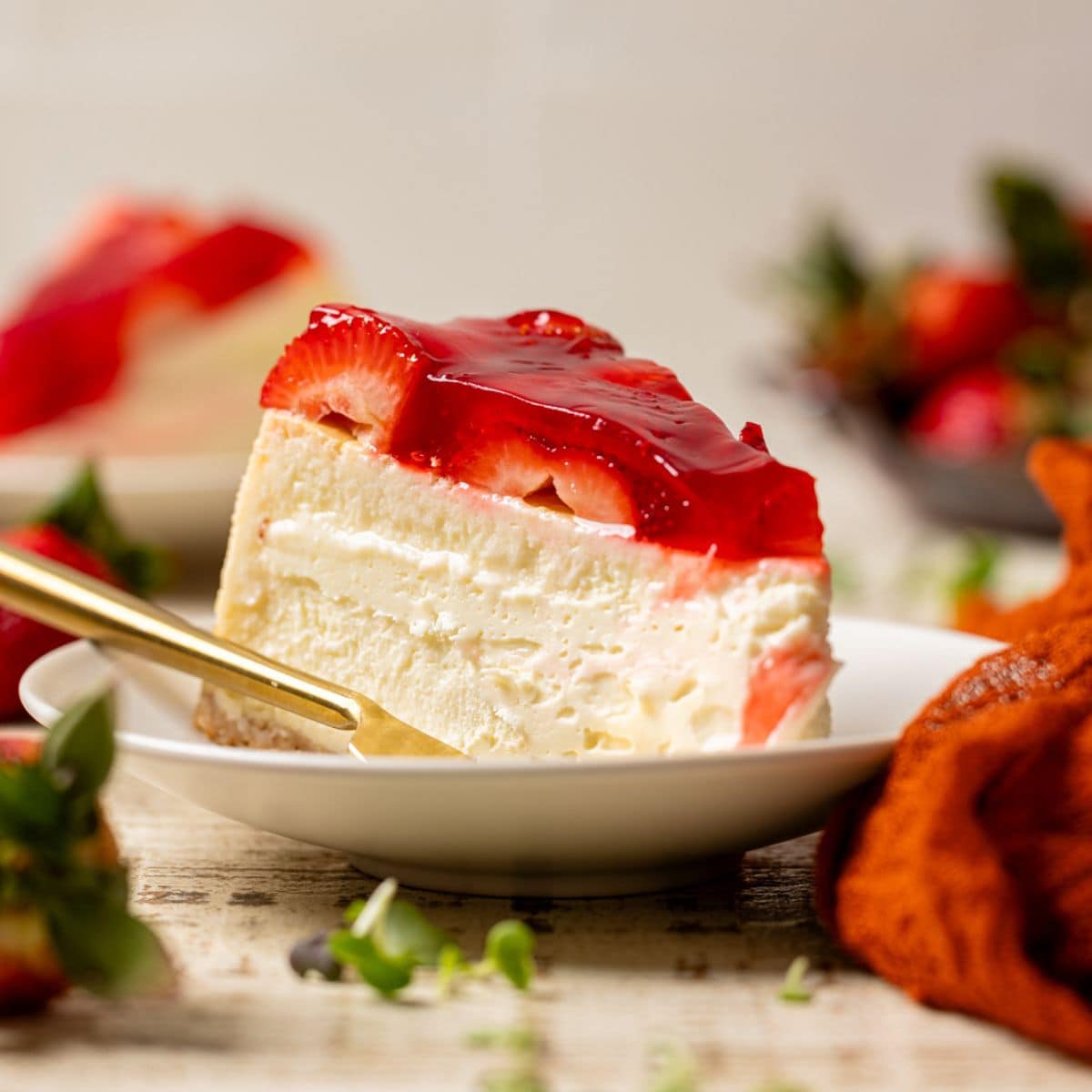 Slice of cheesecake with a fork and strawberries.