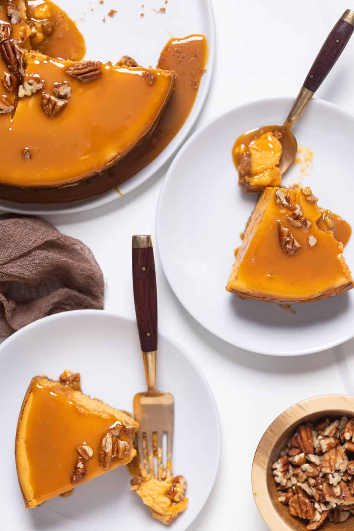 Slices of Sweet Potato Caramel Cheesecake on white plates.