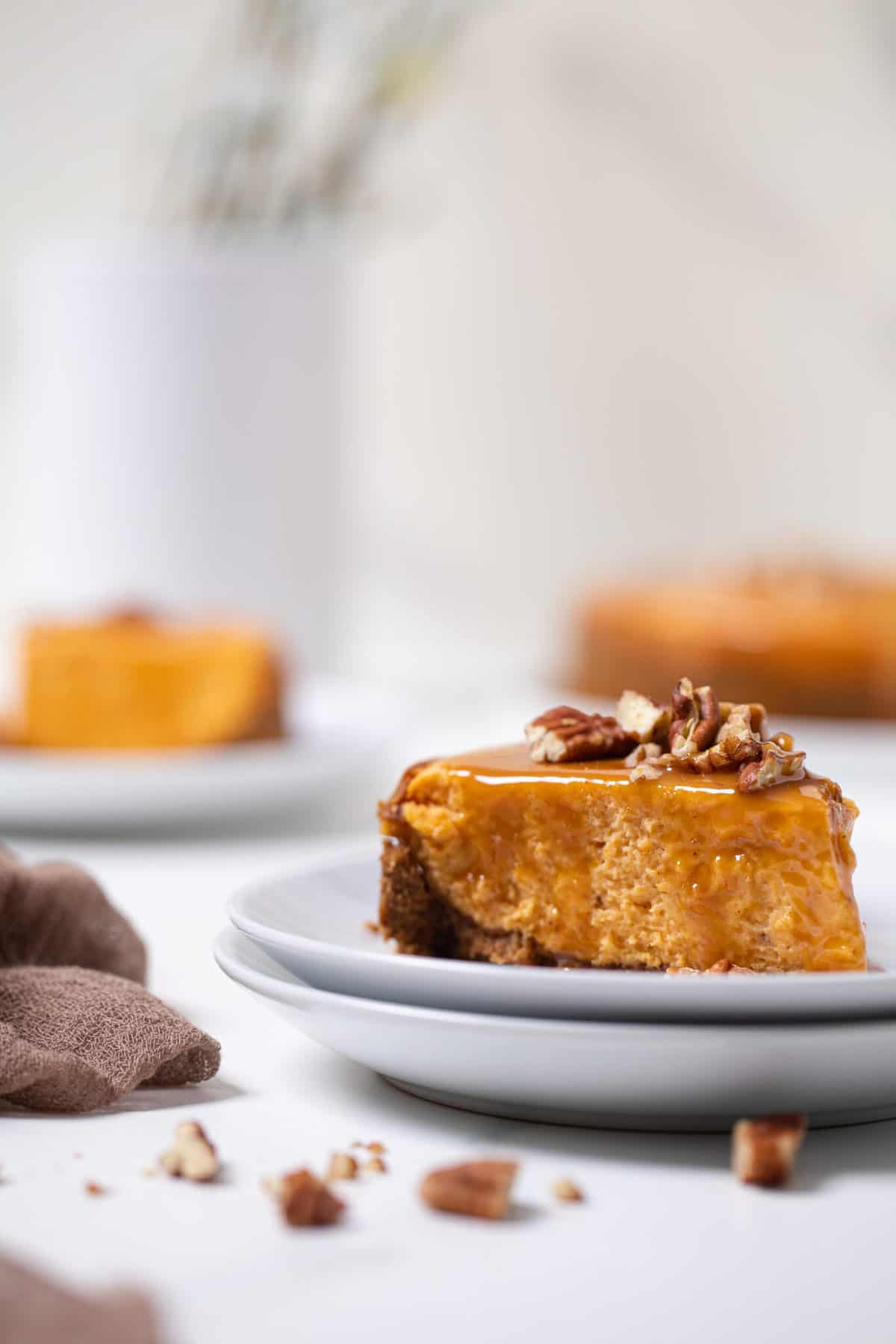 Slice of Sweet Potato Caramel Cheesecake on small, stacked plates.