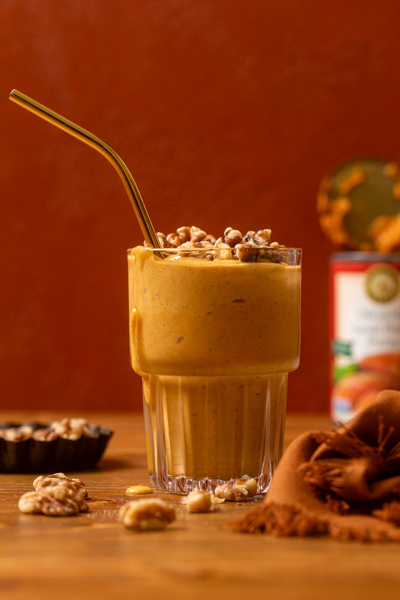 A glass of Cozy Sweet Potato Pie Smoothie with nuts.