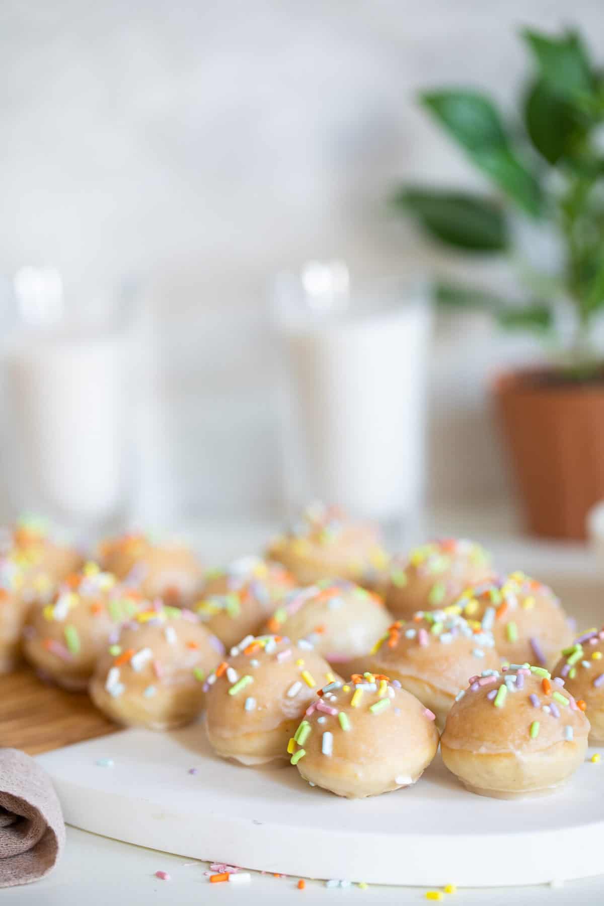 Vegan Sprinkle Donut Holes single layer on a cutting board.