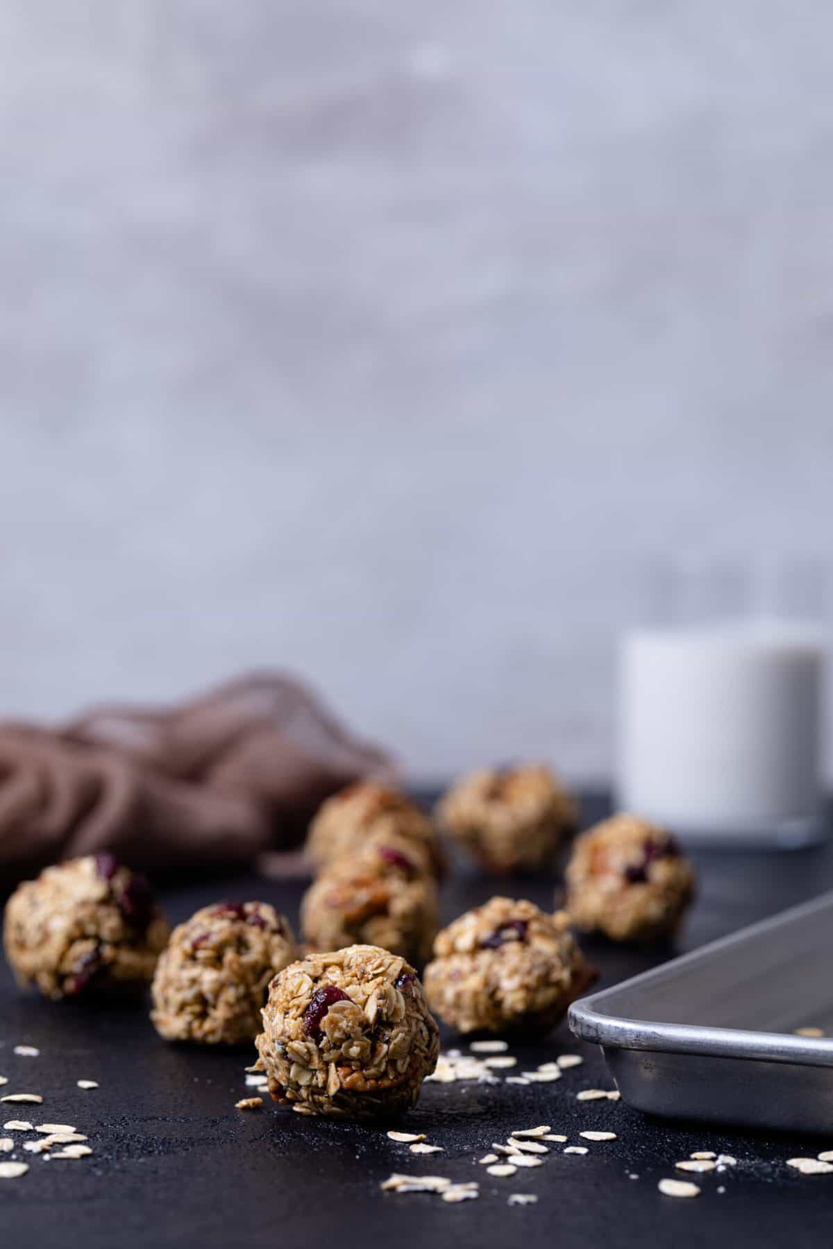 White Chocolate Cranberry Energy Bites next to a baking dish on a black table.