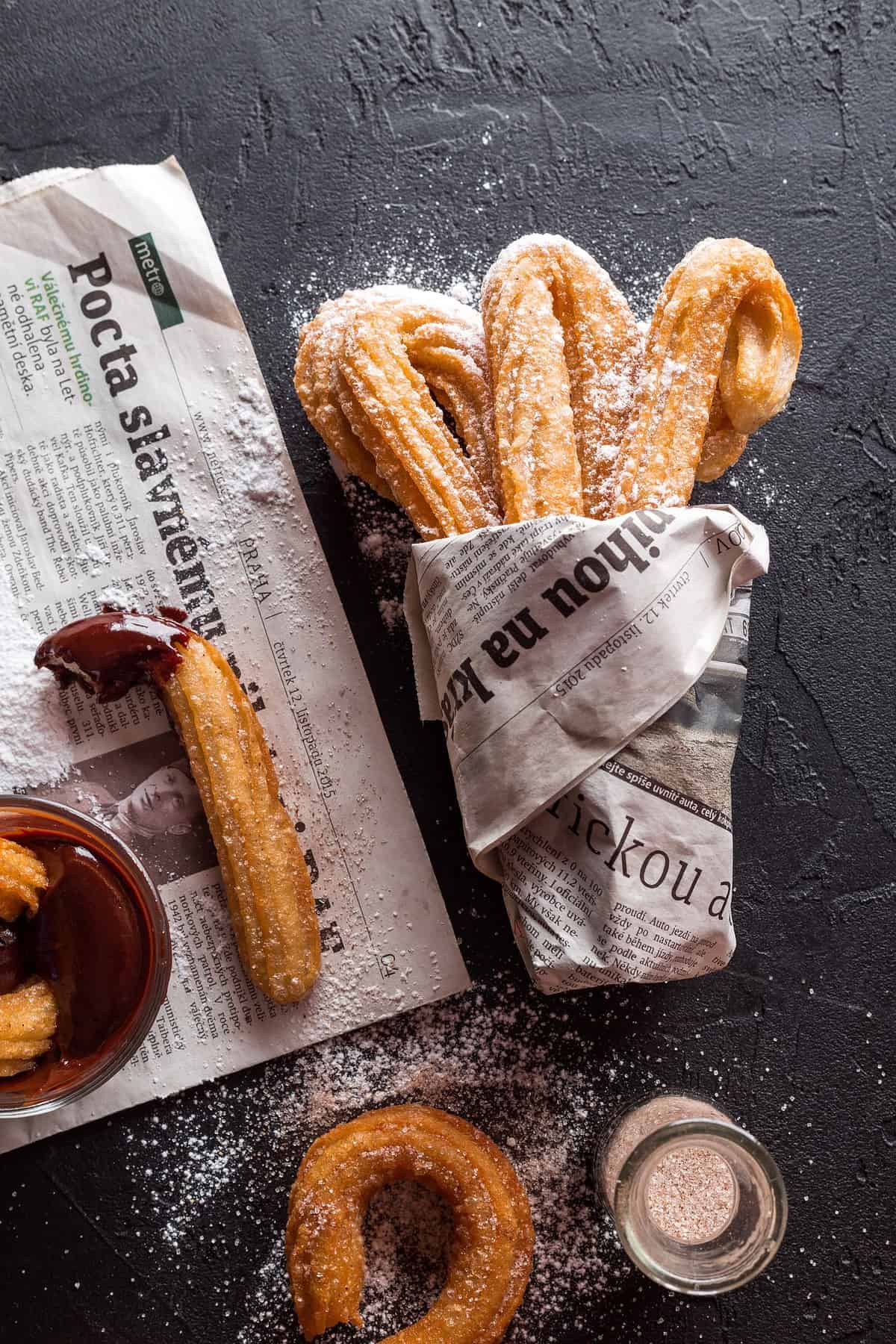 Churros wrapped in newspaper.